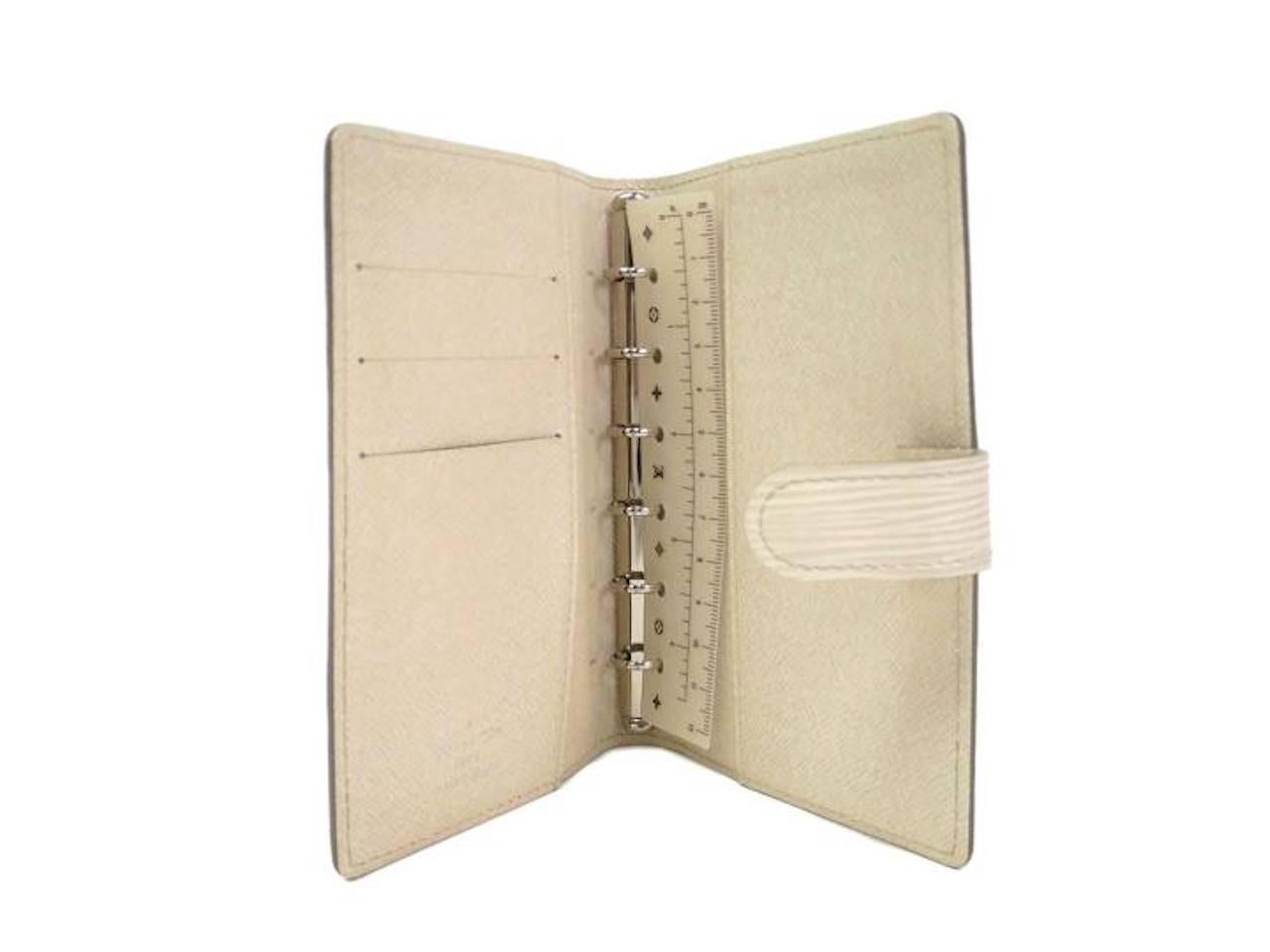 Beautiful, rich ivory agenda versatile enough to compliment any Louis Vuitton collection!

Epi leather
Silver hardware
Snap closure 
Made in Spain
Date code CA1097
Measures 4" W x 5.7" H 
Features two open pocket, pen holder and three card