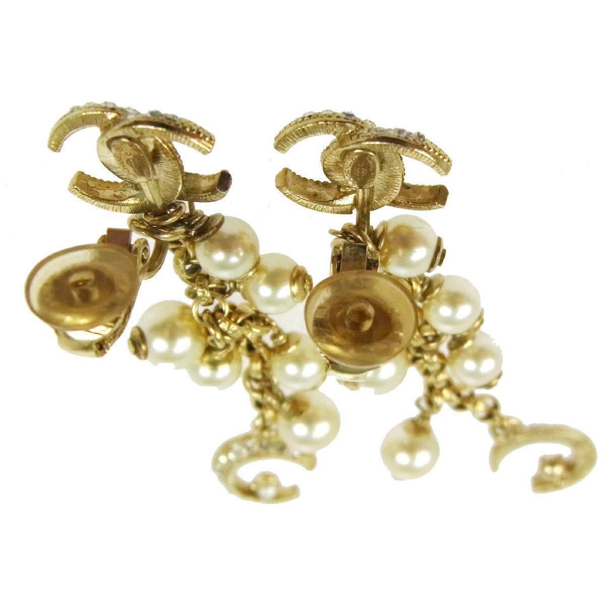 Chanel Like New Gold Faux Pearl Charm Long Dangle Drop Evening Earrings in Box available at Newfound 

Metal
Gold tone
Faux pearl
Clip on closure
Made in France
Width 0.50"
Drop 2.25"
Includes original Chanel box