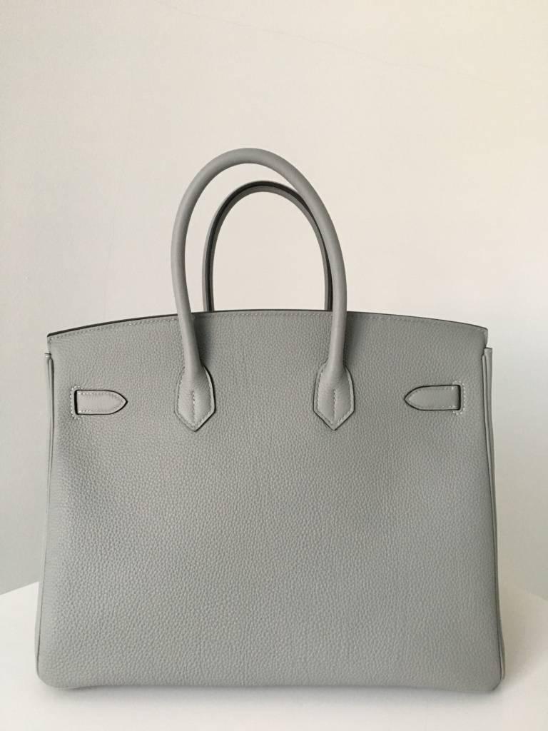 BNIB

The Verso edition has a contrasting interior colour and is quite rare. 

We have on offer a Birkin 35 in Gris Mouette Togo with a Blue Agate interior. Gris Moutte =  sea gull grey

Full set complete with store receipt.

PRICE  INCLUDES