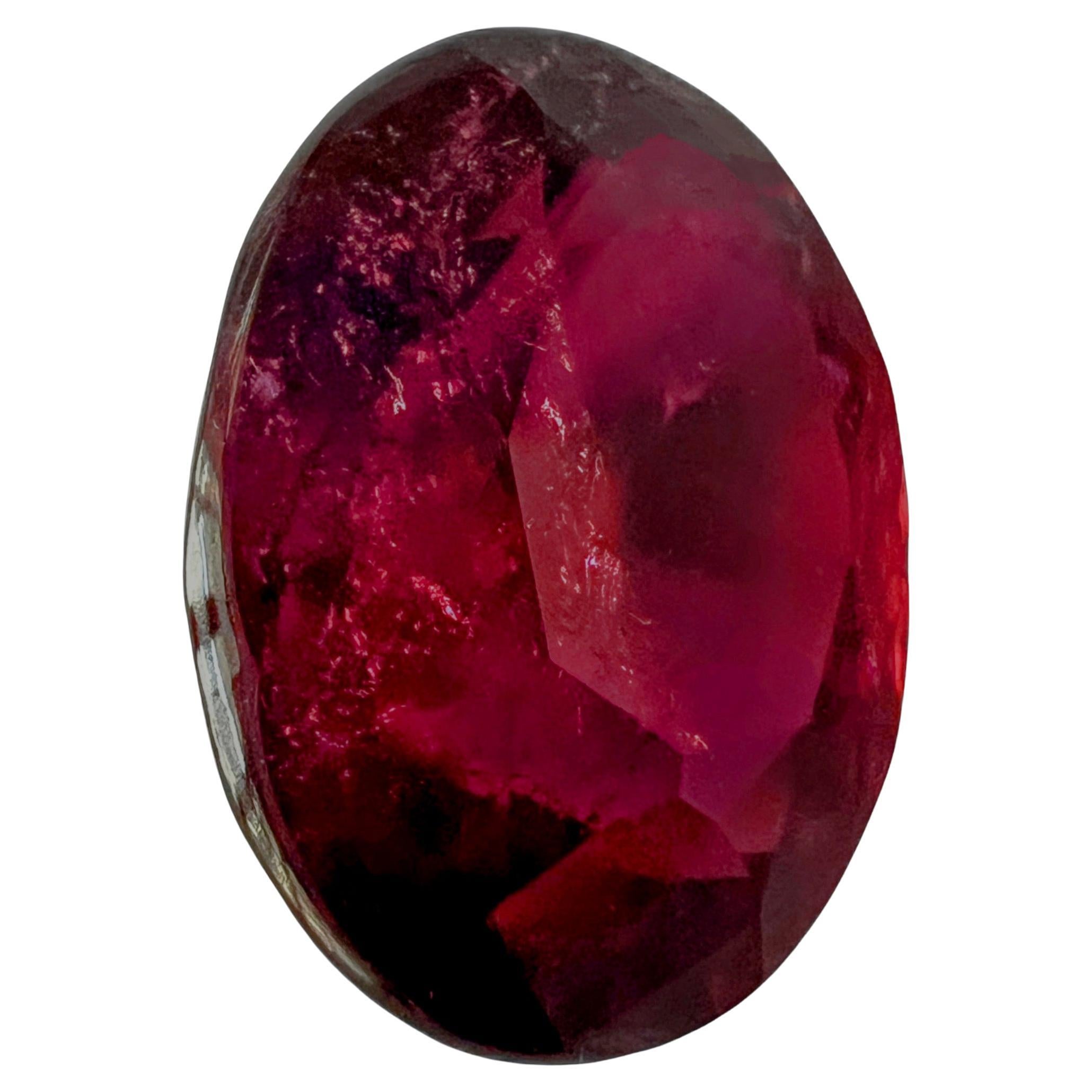 Prepare to be captivated by the radiant beauty of our 18.14ct Oval Intense Red Rubellite Loose Tourmaline with pinkish overtone—a gem that exudes a fiery allure with its remarkable hue and the natural inclusions that add character and depth to its