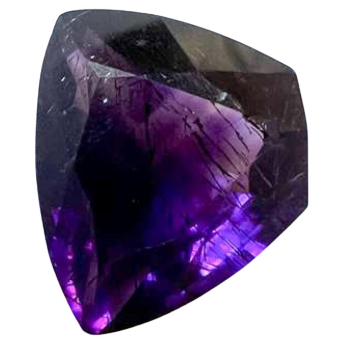 Unleash your creativity with the extraordinary beauty of this 8.63ct Natural Untreated Rutiled Purple Custom Cut Amethyst Loose Gemstone, shaped like a distinctive triangle with a blunt tip. Its estimated measurements and unique shape open up