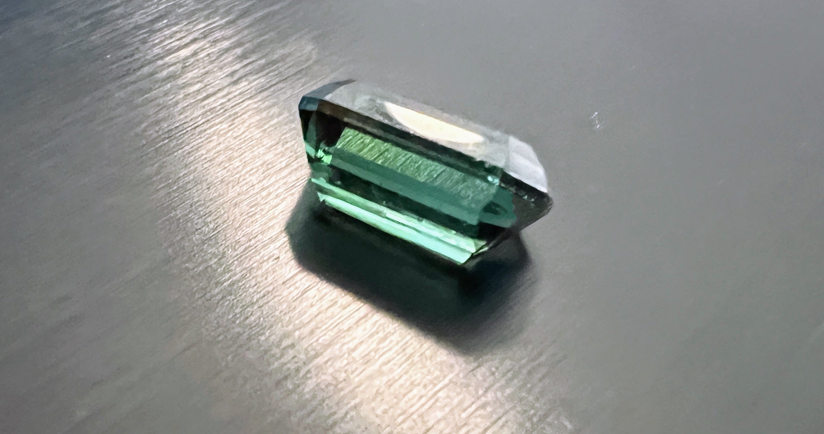 Enjoy the true beauty in this 5.41ct Deep Green Emerald Cut Tourmaline, a hidden gem waiting to grace your collection. At first glance, you might think you're gazing upon a natural emerald. This tourmaline boasts a lush, deep green hue with a