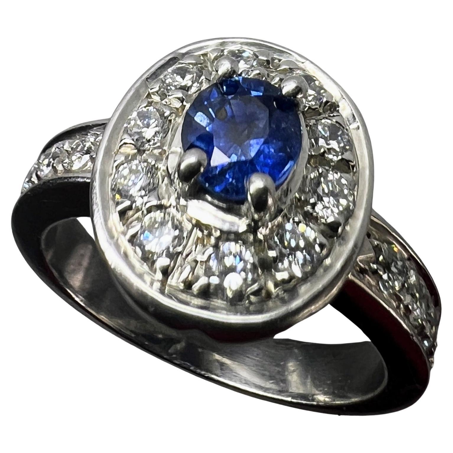 Celebrate your love story with our 1ct Natural Oval Blue Sapphire Engagement Ring, a symbol of eternal commitment and exquisite beauty. This stunning ring features a 1ct blue oval sapphire at its center, flanked by a radiant display of 10 sparkling