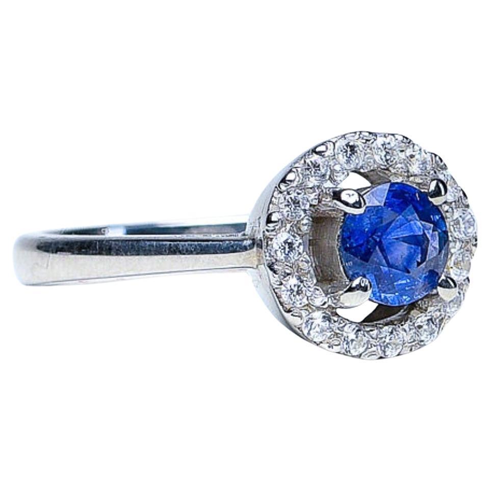 Wir präsentieren unseren bezaubernden blauen Saphir von 1,5 Karat, umgeben von einem Halo aus glitzernden weißen Zirkonen in unserem Floating Halo Ring - eine Verkörperung von zeitloser Schönheit und ewiger Liebe. Dieser exquisite Ring ist ein Fest