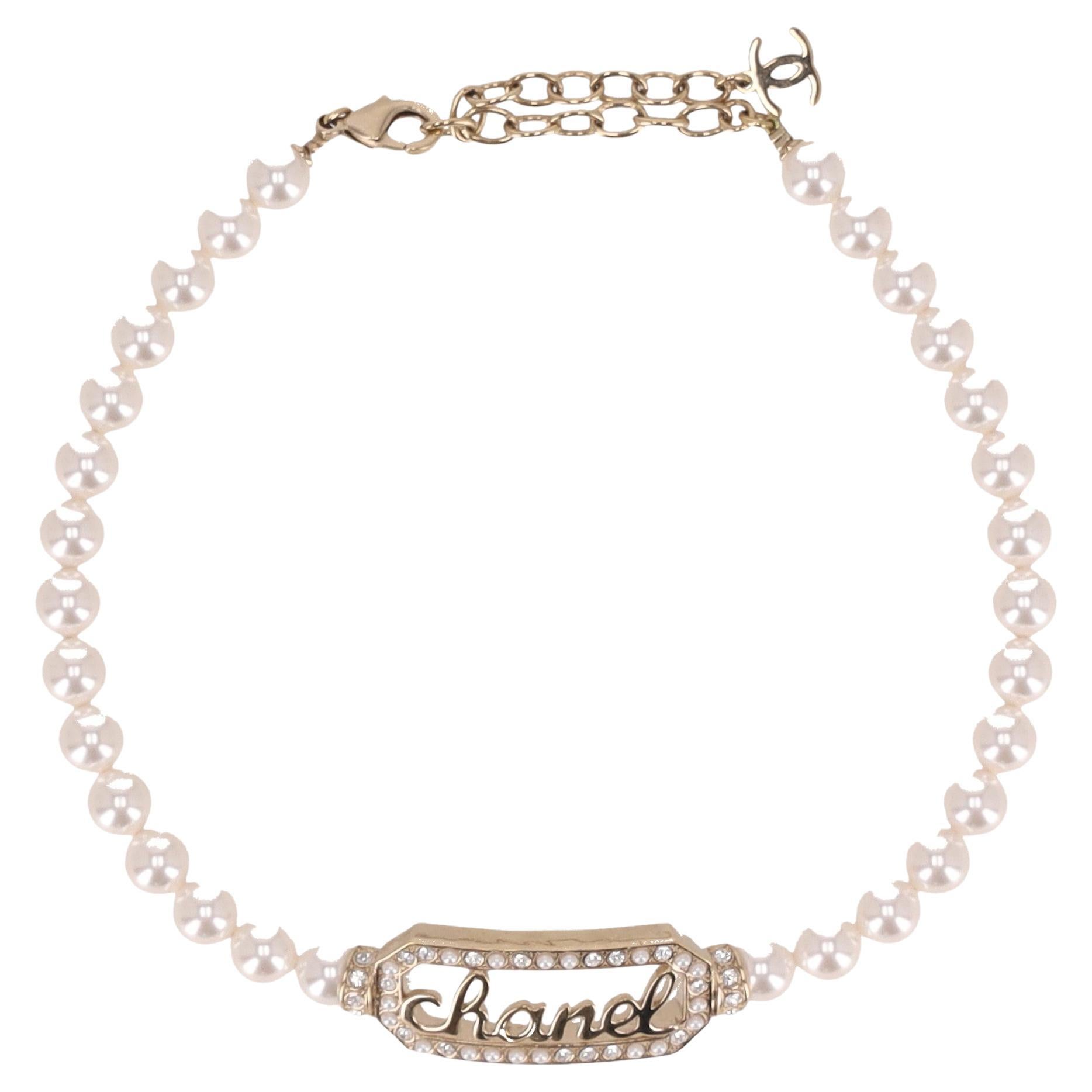Collana Chanel con collana di perle e firma "Chanel" impreziosita da cristalli