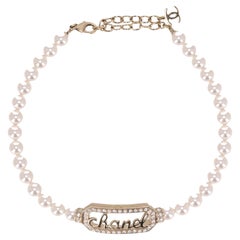 Collar gargantilla de perlas Chanel con firma "Chanel" embellecida con cristales