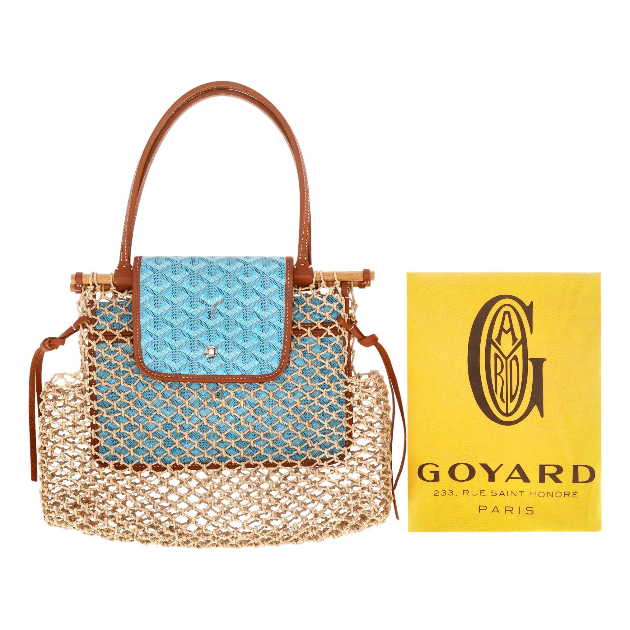 Wir verehren - Goyard Goyardine Ltd Edition Net Aligre Raffia Mesh Tote Bag

Handgeflochtener Korpus aus beigefarbenem Raffiabast, umrahmt von Holzstäben, gekrönt von der kultigen Klappe aus beschichtetem Goyardine-Canvas in Blau mit braunem