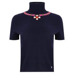 Top in cashmere Chanel 23N con logo "CC" in cristallo e collana Gripoix con motivo grafico