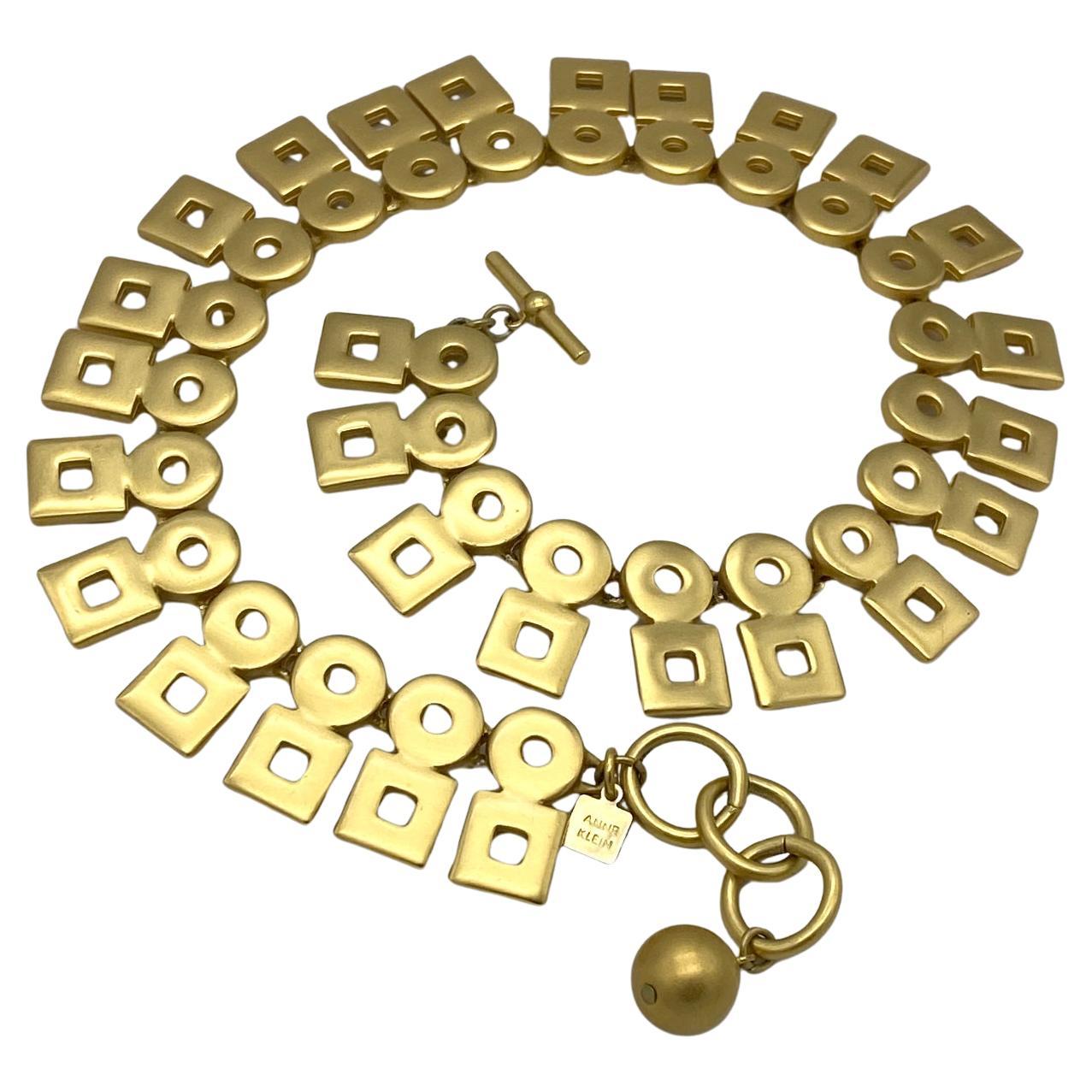 Dieses Collier aus russischem Gold von Anne Klein aus den 1990er Jahren besteht aus modernen kreisförmigen und quadratischen Elementen. Es hat einen Knebel an einem Ende und drei Ringe am anderen Ende zur Längeneinstellung.

Unsere