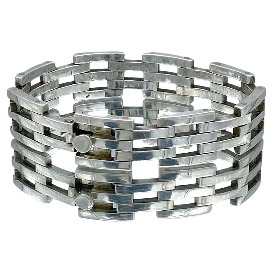 This is an Art Deco style sterling silver bracelet. It has rivited industrial looking segments with a box clasp. Sometimes called a tennis bracelet. Marked TP-81 925 Mexico on the inside surface.

Our vintage jewelry collection and original
