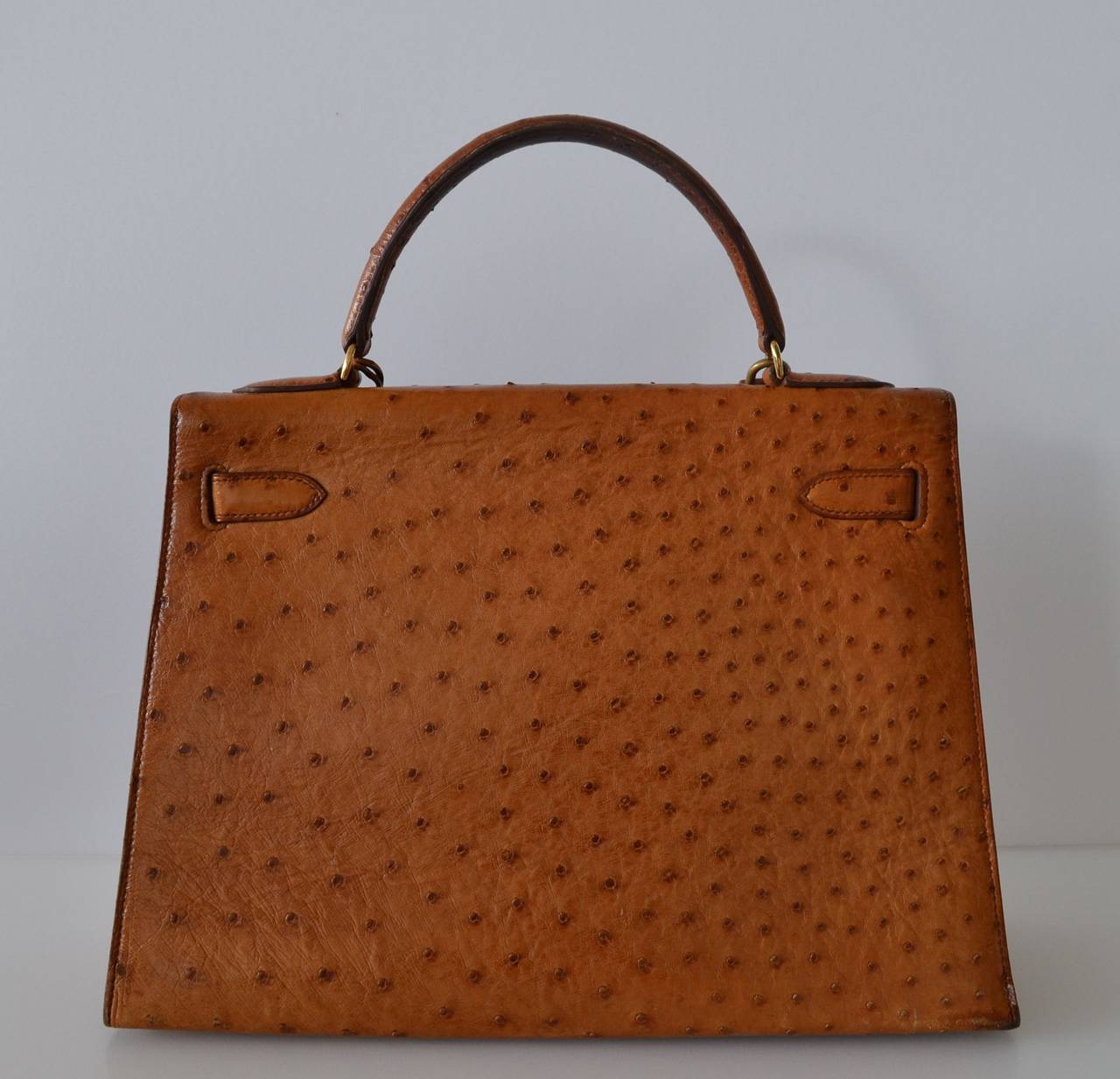 Hermès Kelly 32 Ostrich Gold Sellier
 
Hermes Kelly Sellier handbag
 
Ostrich skin in gold color
Gold plated hardware
 
Very good condition – 7/10
Gentle scratches on hardware
Handle and corners are very good.
Interior is very clean and