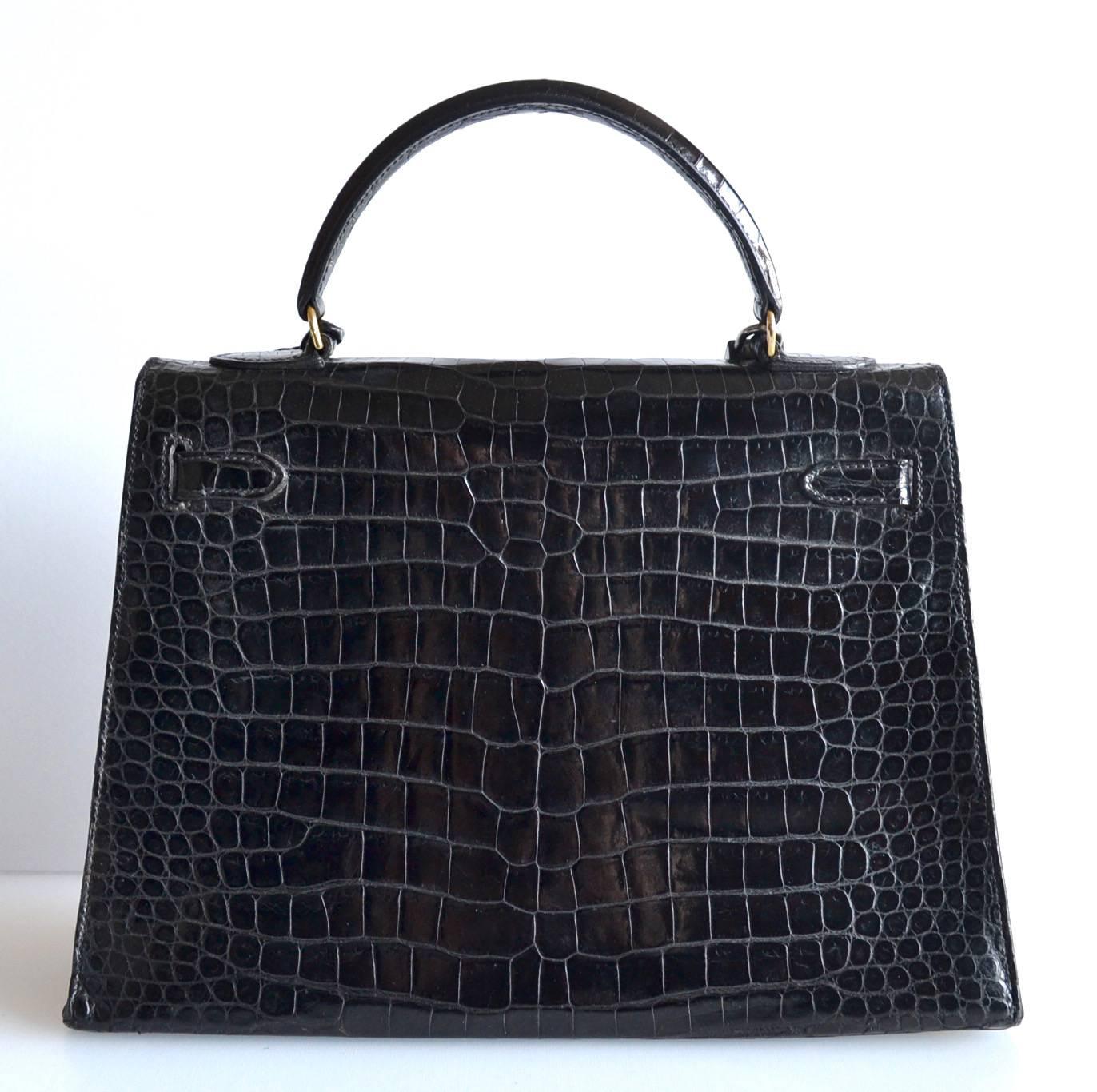 Hermes Kelly 32 Black Crocodile
 
Black shiny crocodile skin with gold hardware
Sellier model
 
The bag is lined with chevre leather. Interior is in good condition with a zipper pocket.
This bag is in good condition. It is a vintage bag. Normal use