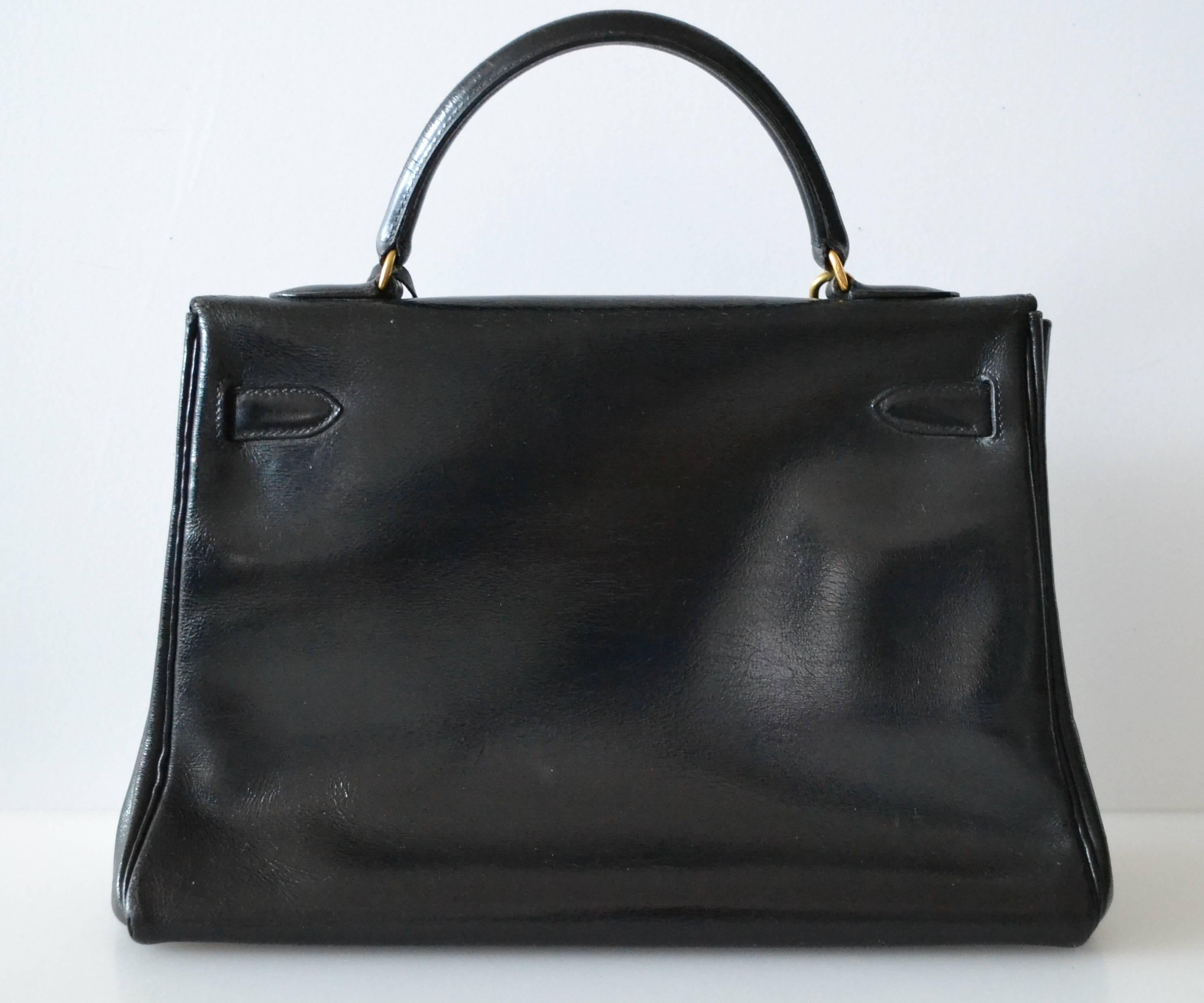 Hermes Kelly 32 Black Box
 
Black box leather with gold hardware
Retourne modèle
 
The bag is lined with chevre leather. Interior is in good condition with a pocket.
This bag is in good condition.
It is a vintage bag from 60s. Normal use. The Box