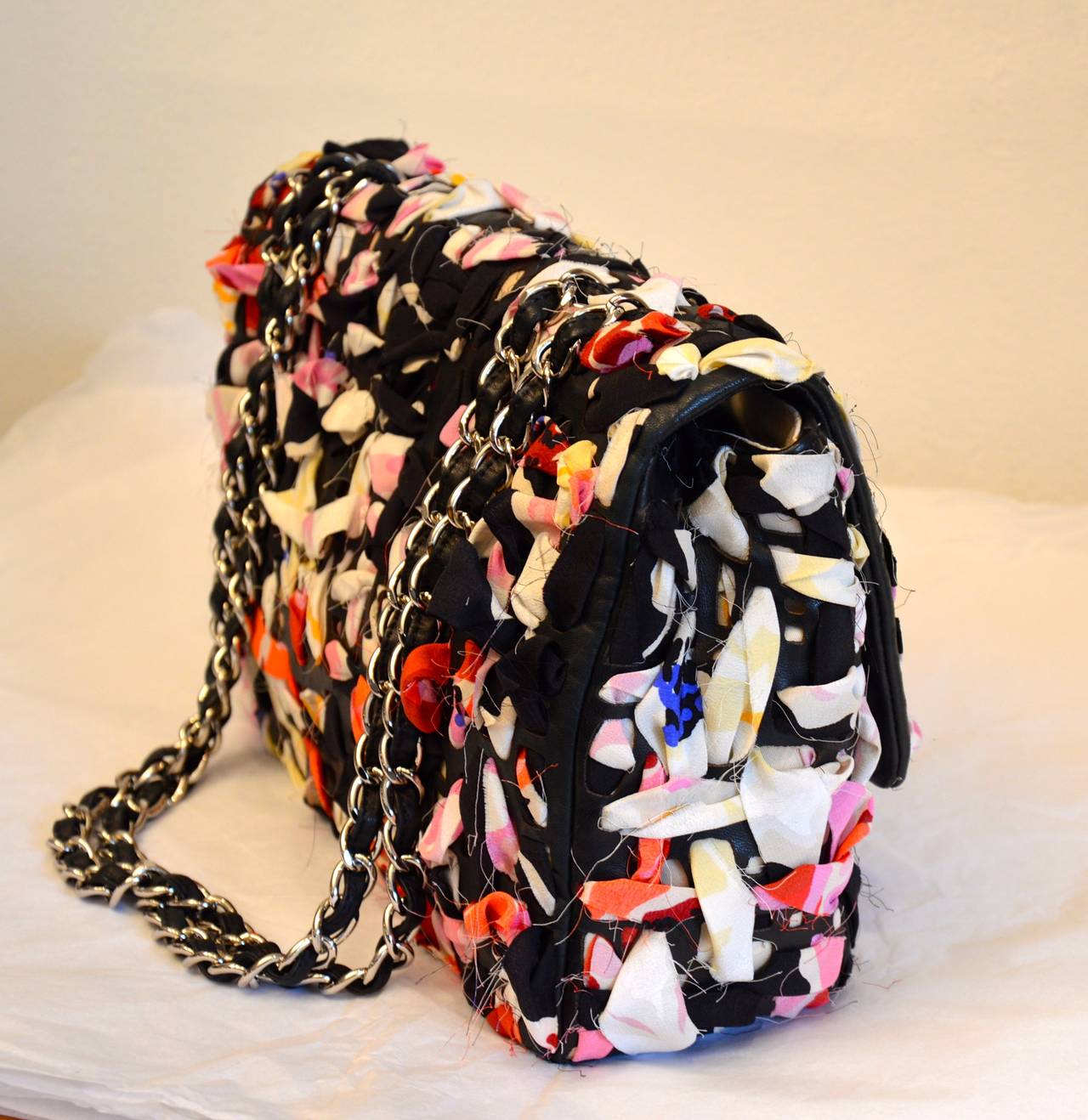 This is an authentic CHANEL XL Jumbo Flap in Vivid Colored Silk . This is a stunning large vintage flap bag that is beautifully crafted of black soft lambskin leather interlace with pastel and vivid colors. The bag features silver chain link