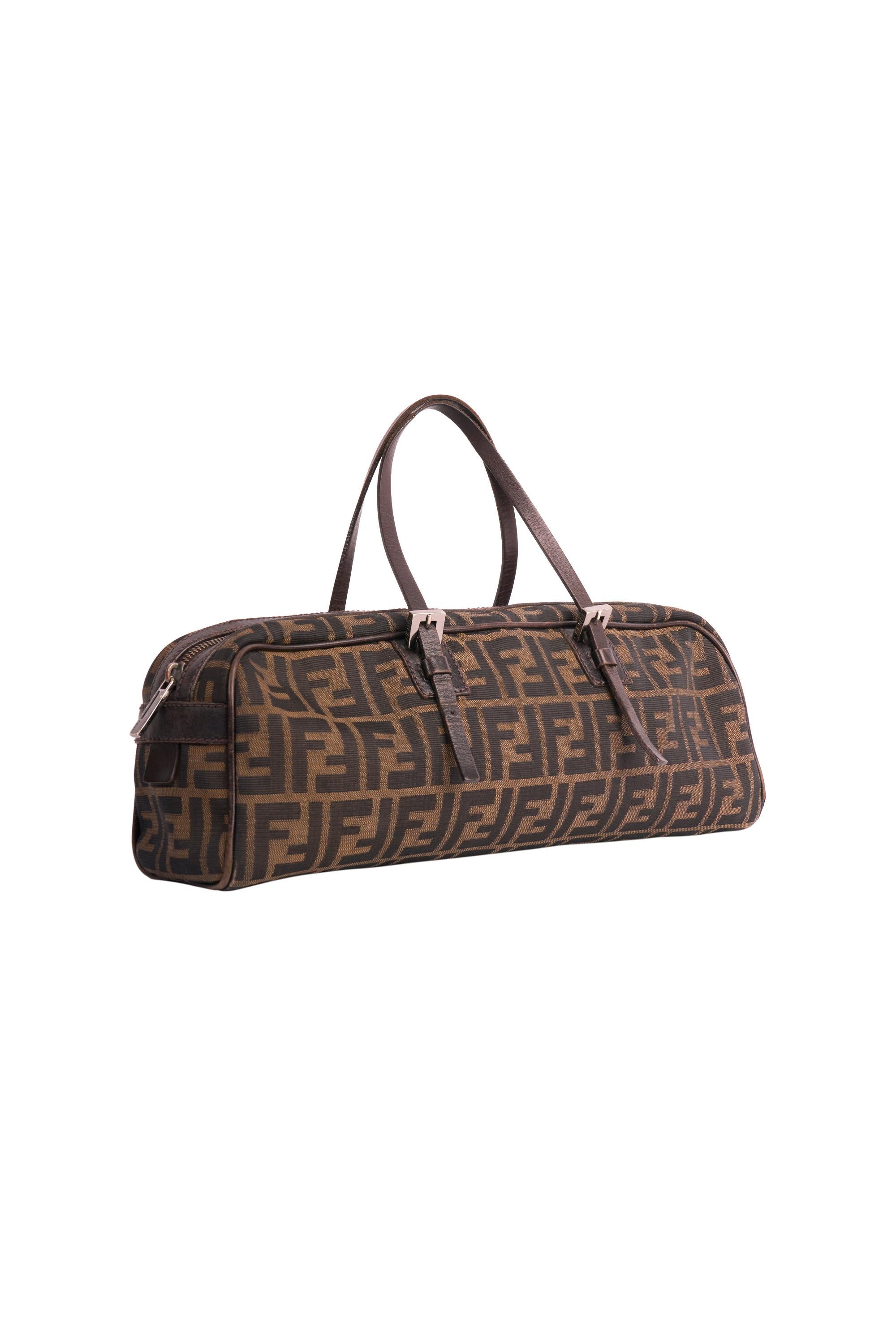 Sac de bowling vintage Fendi des années 1990. Comprend une toile monogramme en zucca marron, une poche intérieure zippée au dos. Bracelet en cuir avec longueur réglable et boucles en métal Fendi. Fermeture à glissière sur le dessus. 