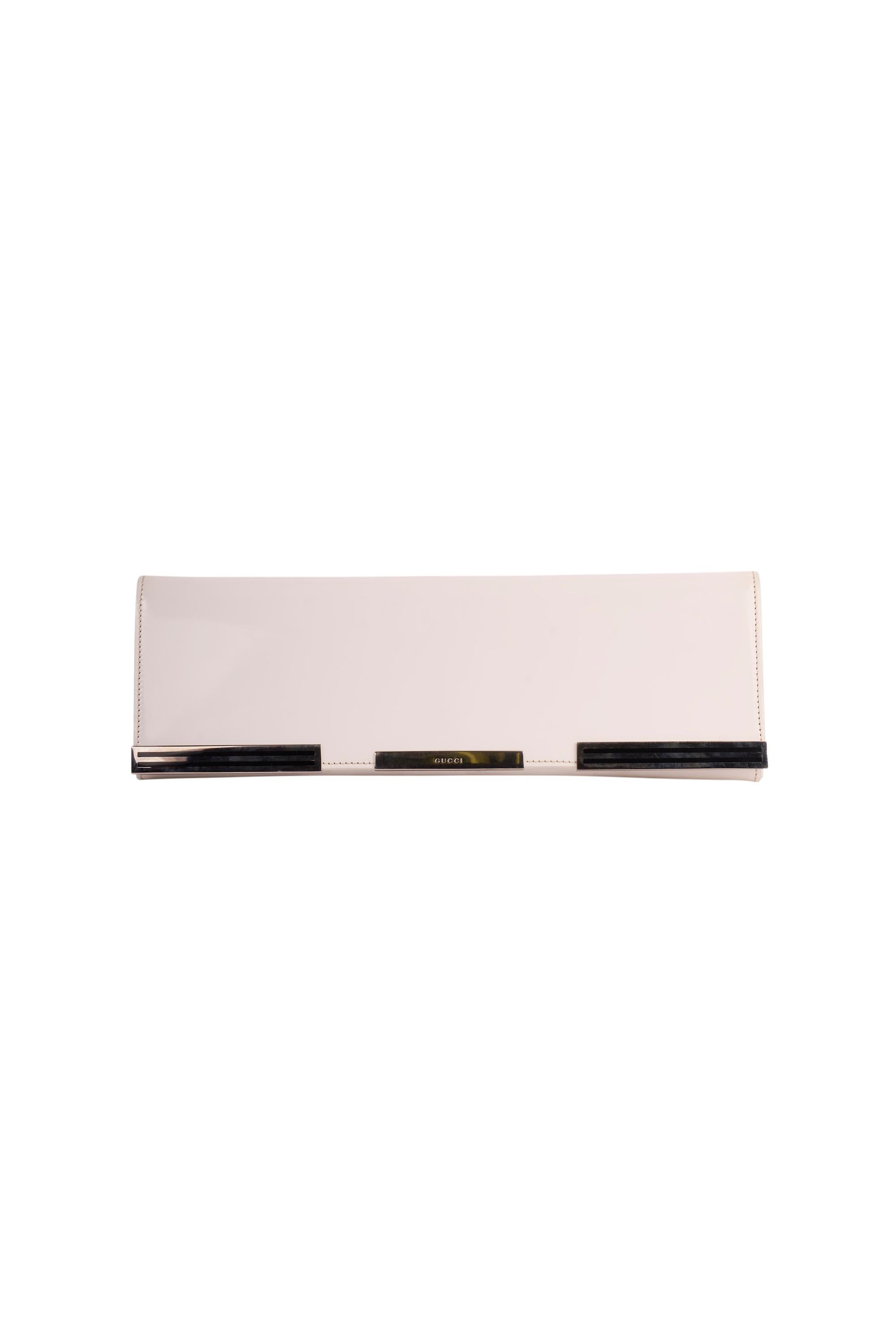 Pochette rectangulaire Vintage Gucci des années 1980 - pièce de collection. Whiting, en cuir verni blanc, avec des détails en argent et le logo Gucci gravé sur le devant.  Livré avec un petit miroir de poche rectangulaire. Fermeture magnétique