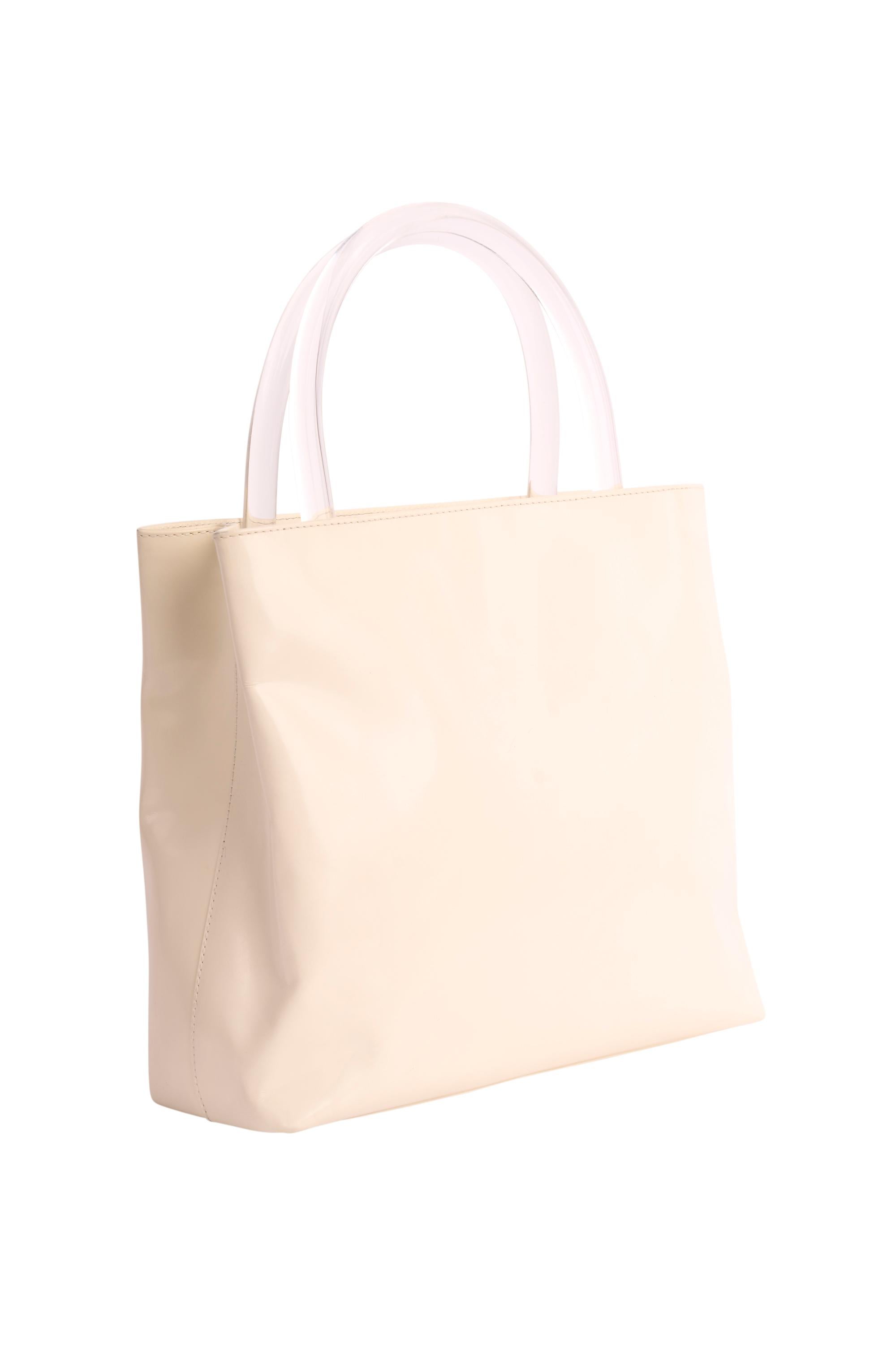 Vintage Prada 1990's cuir blanc verni mini tote bag . Whiting comprend un corps en cuir verni blanc, deux petites poignées en plexi, une poche centrale zippée et une petite poche intérieure zippée.  Le logo Prada est gravé à l'intérieur de la partie