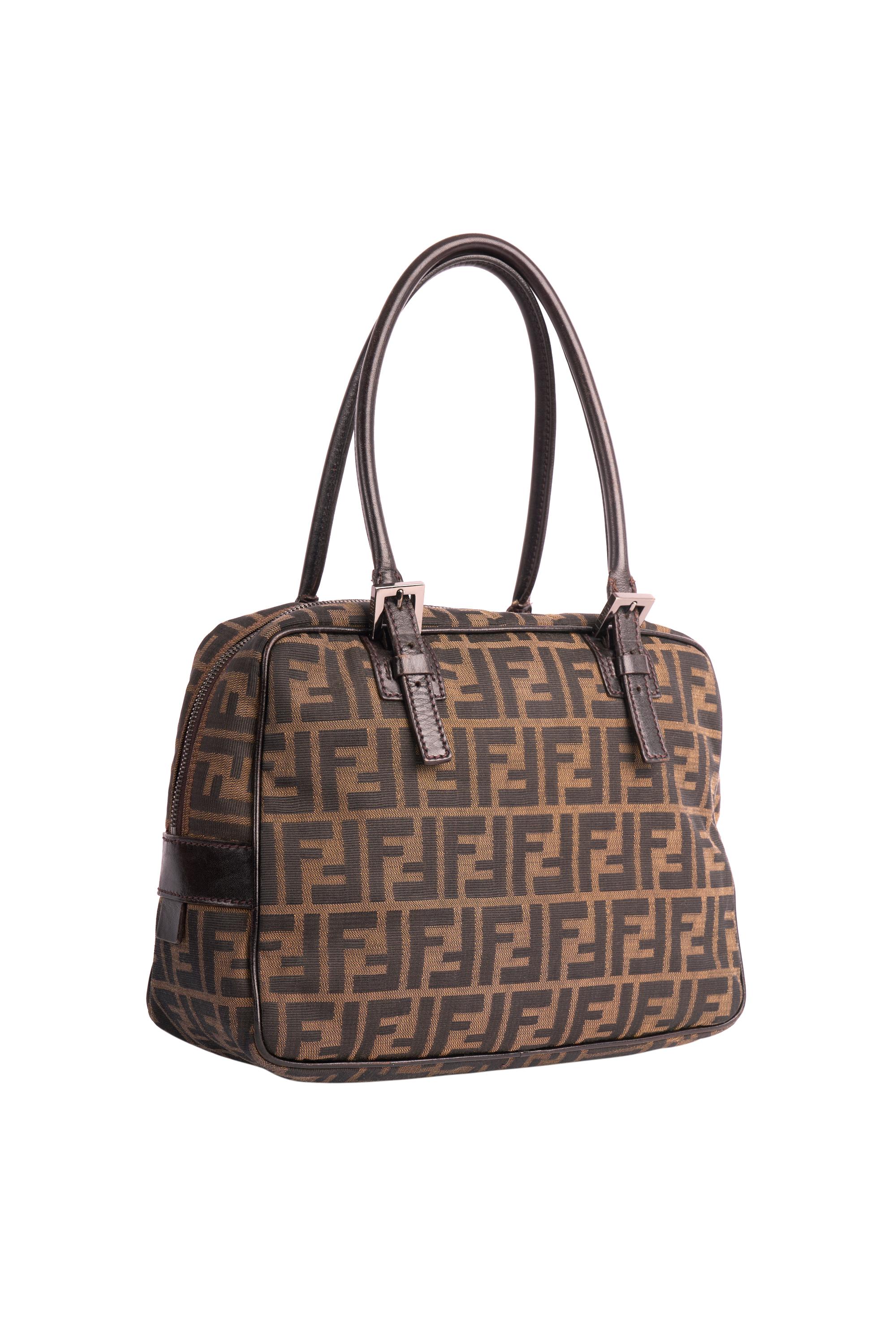 Vintage Fendi 1990's petit sac fourre-tout. Monogramme imprimé en zucca marron,  Fermeture zippée sur le dessus, sangle en cuir réglable en longueur et boucle en métal signée Fendi. Elle est en excellent état. 
