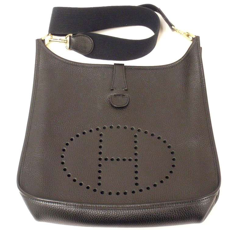 HERMES EVELYNE GM BLACK CLEMENCE GHW SHOULDER BAG, 2004

 This bag is in EXCELLENT condition. Features soft leather exterior with sueded leather interior. Black clemence leather and  blue canvas strap.

Please note, color can vary greatly from