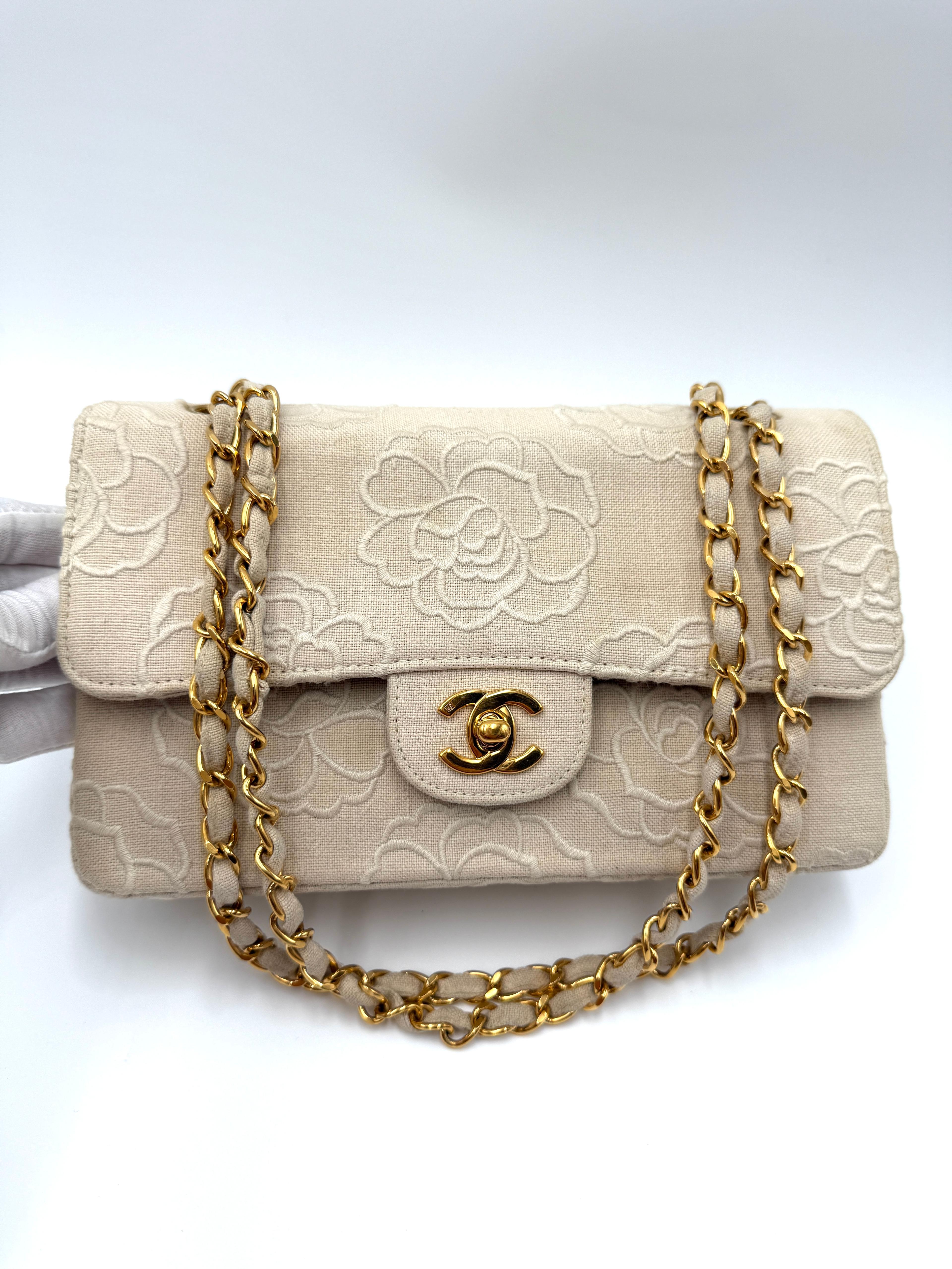 Modèle incroyablement rare et apprécié de Chanel, ce petit rabat beige présente l'emblématique motif floral Camélia délicatement brodé sur un corps en toile. Le cadenas CC en métal doré ajoute une touche d'élégance discrète.

Cette pièce est en