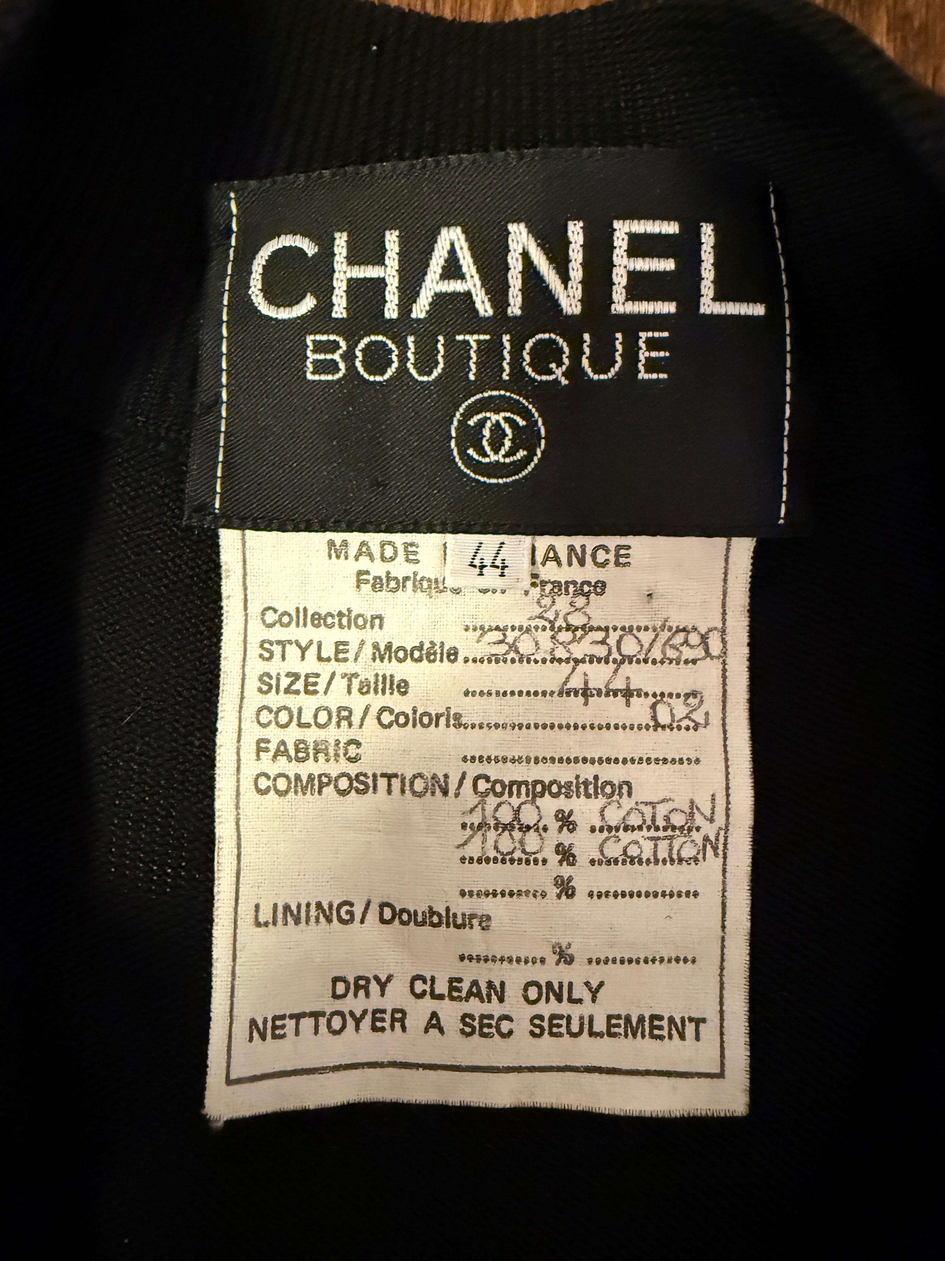 Un pezzo incredibilmente raro della collezione Chanel del 1993, questa tuta nera è un esempio di lusso vintage senza sforzo. Realizzato in una maglia morbida e confortevole, presenta un frontale con bottoni, una coulisse in vita per una vestibilità