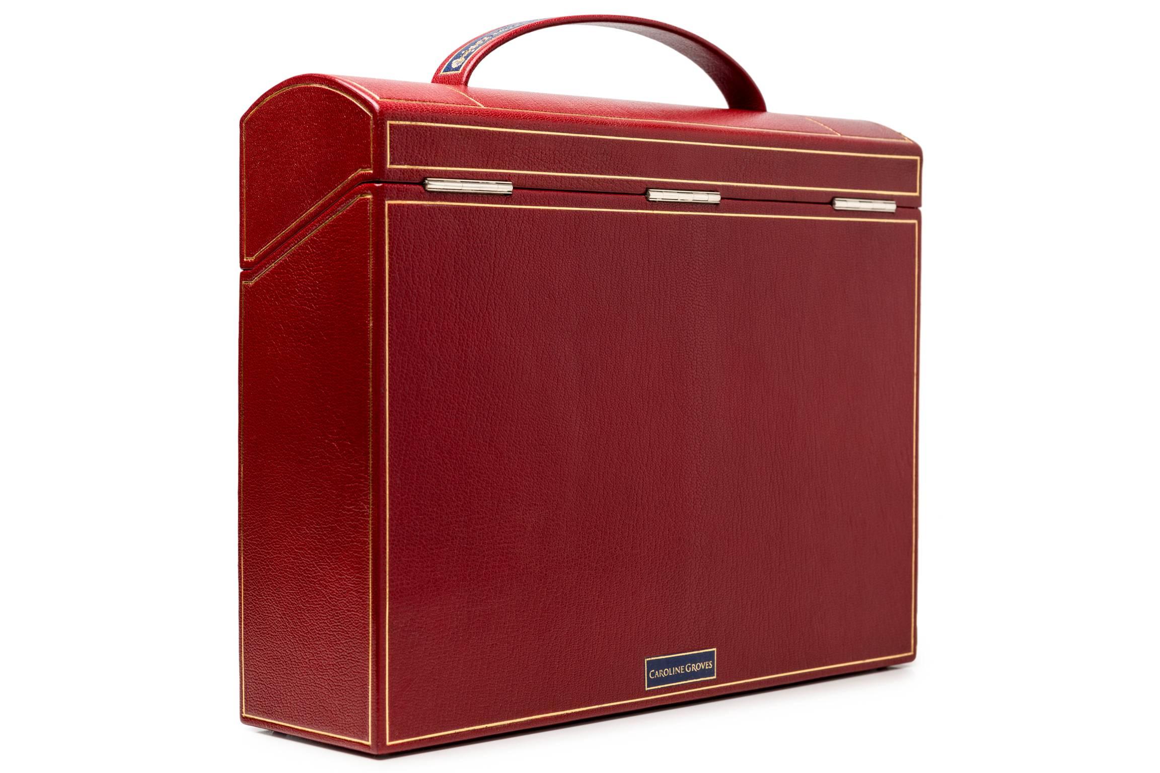 The Cleeve Case is inspired by a late Georgian portable writing desk. The red goatskin case over a carcass of wood has inlays of green and blue with over fifty hours of hand tooling by Trevor Lloyd with 22 carat gold. At the corners are sapphires