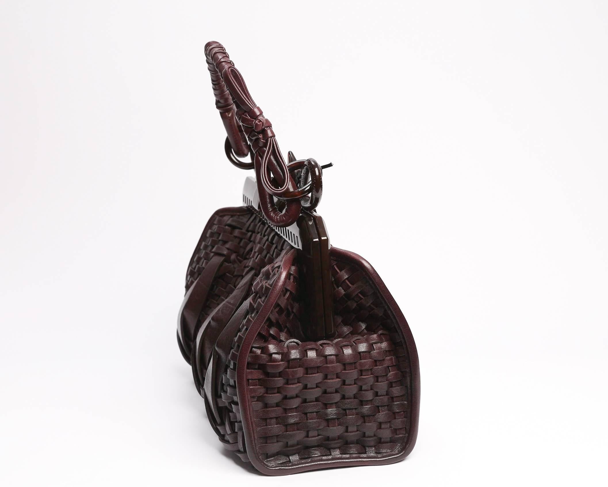 Dark brown woven leather Christian Dior Samourai handle bag with snake motif at handle, interior zip pocket and top flip-lock closure.
Brown Christian Dior lining.
Strap drop 7 inches.
New with tags, care cards and original duster.