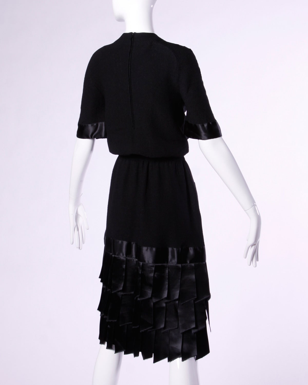Vintage black knit dress with ribbon trim and fringe by Adolfo for I. Magnin. Gold buttons and short sleeves.

Details:

Unlined
Back Zip Closure
Estimated Size: Small- Medium
Color: Black
Fabric: Knit
Label: Adolfo for I.