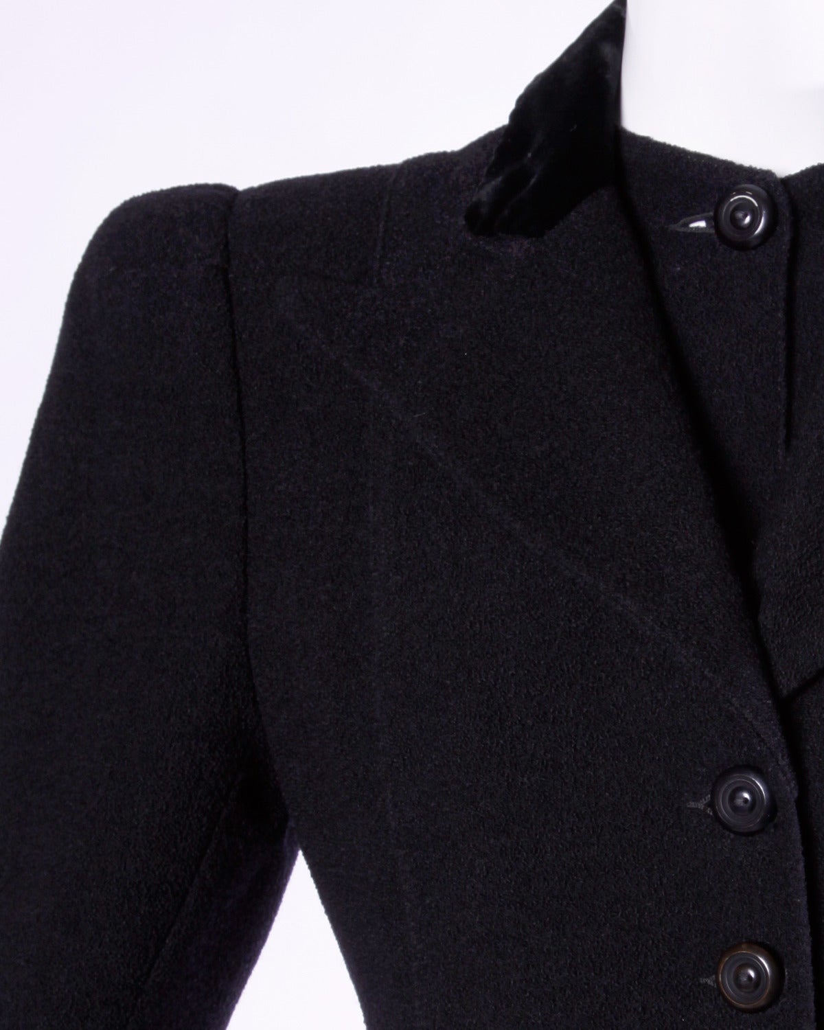 Gorgeous black wool tailored coat from the 1940s featuring bold shoulders and flared princess shape. Unique collar detail buttons under the lapels giving the appearance of a second piece.

Details:

Fully Lined
Front Button Closure
Estimated