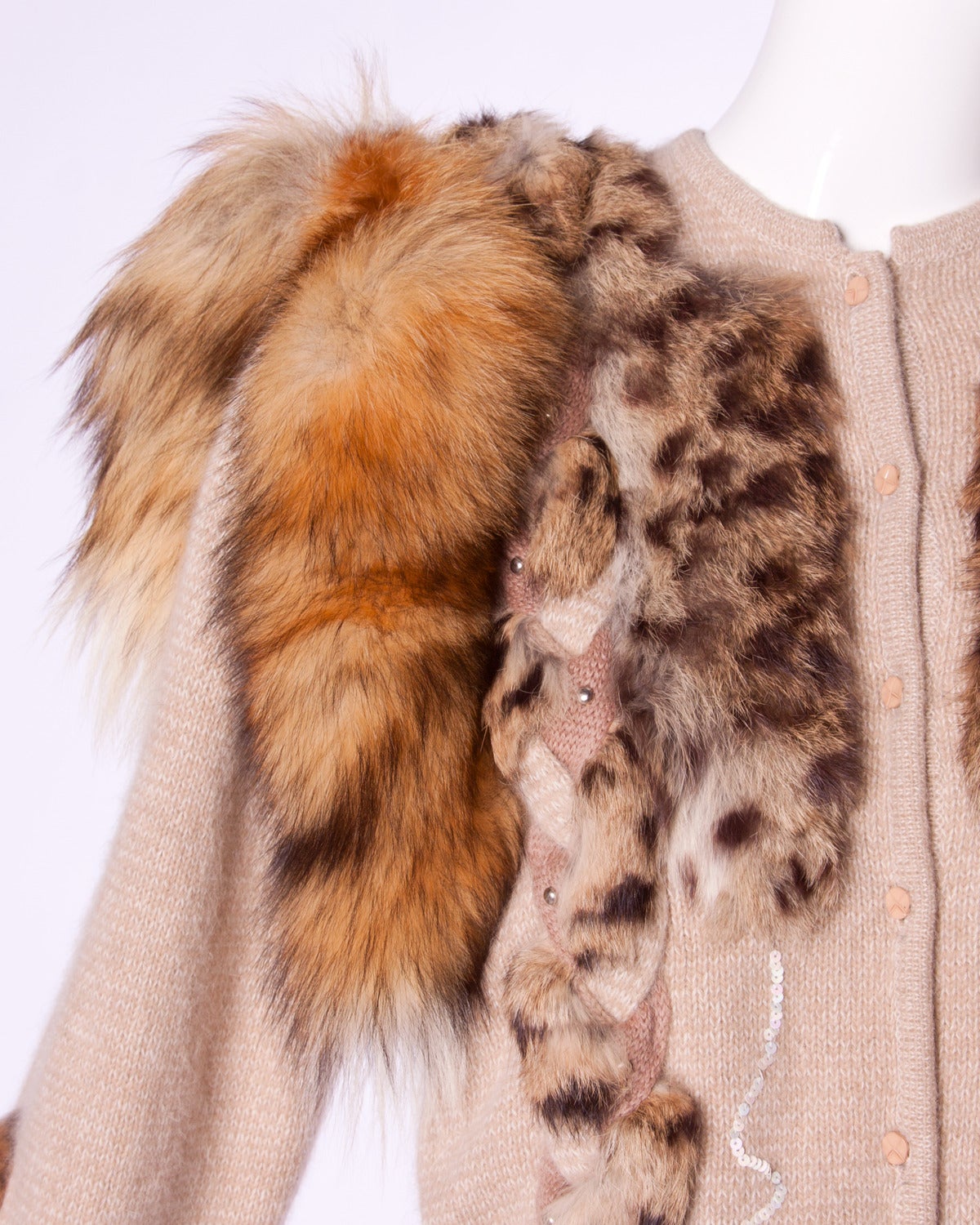 Unworn with the original tags still attached! Vintage soft knit cardigan sweater with fox tails and leopard dyed fur patchwork. 

Details:

Unlined
Front Button Closure
Marked Size: Not Marked
Color: Copper/ Beige/ Cream
Fabric: Angora/