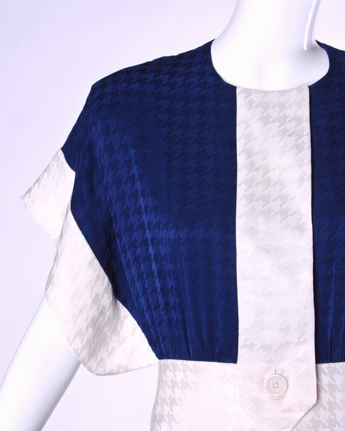 Gorgeous color block dress with batwing sleeves by I. Magnin. Houndstooth silk fabric.

Details:

Unlined
Side Pockets
Front Button Closure
Circa: 1980's
Marked Size: 12
Estimated Size: M
Color: Navy Blue/ White
Fabric: 100%