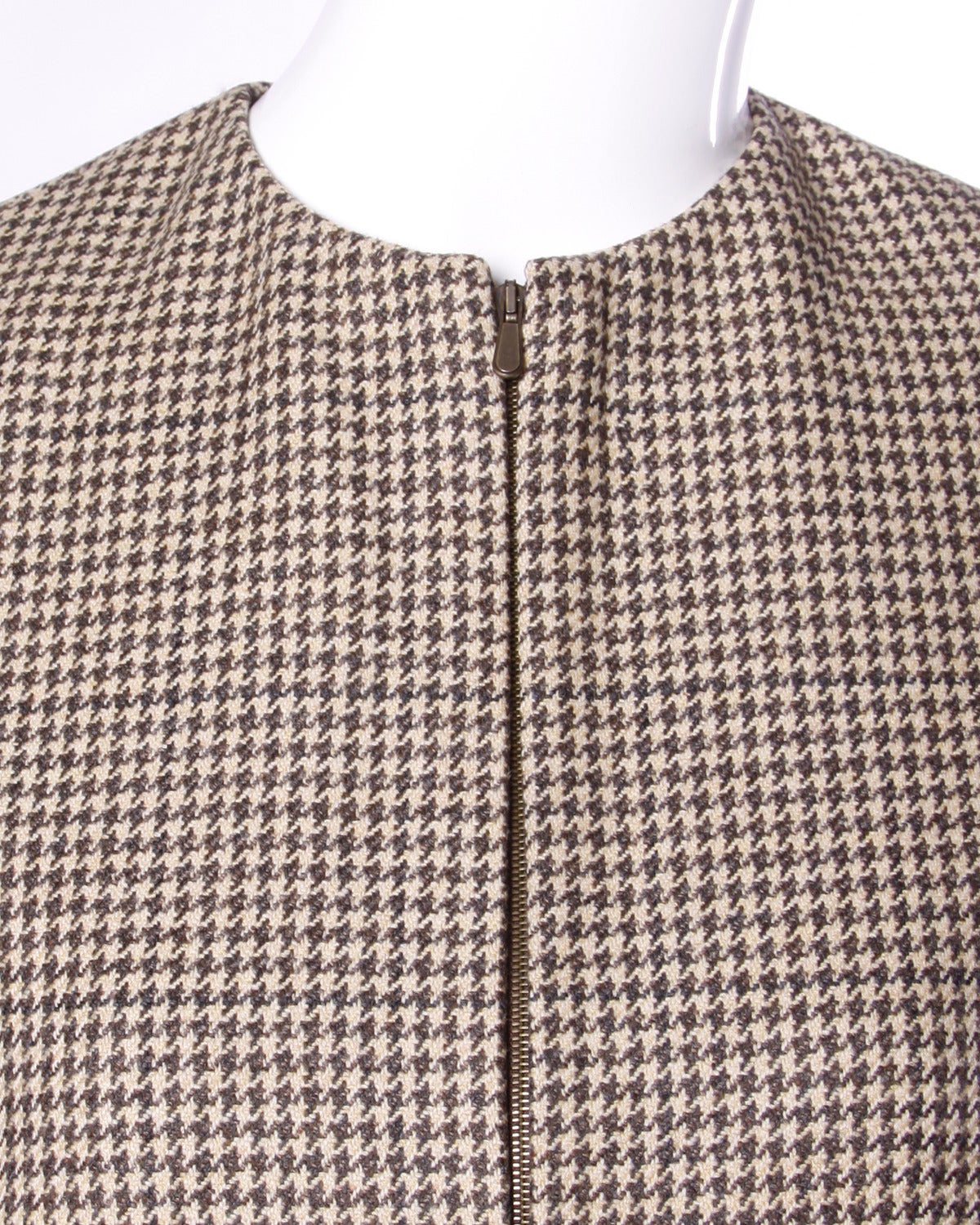 YSL two piece skirt suit in a hard-to-find larger size! Wool houndstooth minimalist design with classic clean tailoring.

Details:

Fully Lined
Side Pockets On Top
Front Zip Closure On Jacket/ Back Button and Zip Closure On Skirt
Color: Tan/