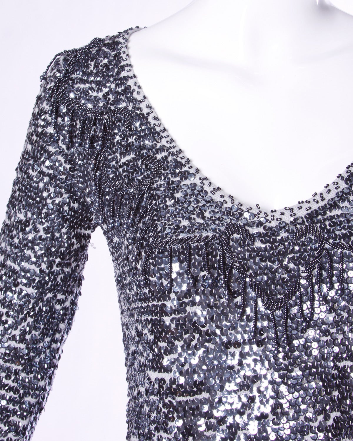 Vintage Giorgio Sant'Angelo merino wool knit sweater top with metallic gray sequin and beadwork. Long sleeves and beaded fringe.

Details:

Unlined
No Closure
Marked Size: Small
Color: Gray Metallic
Fabric: Merino Wool
Label: Giorgio