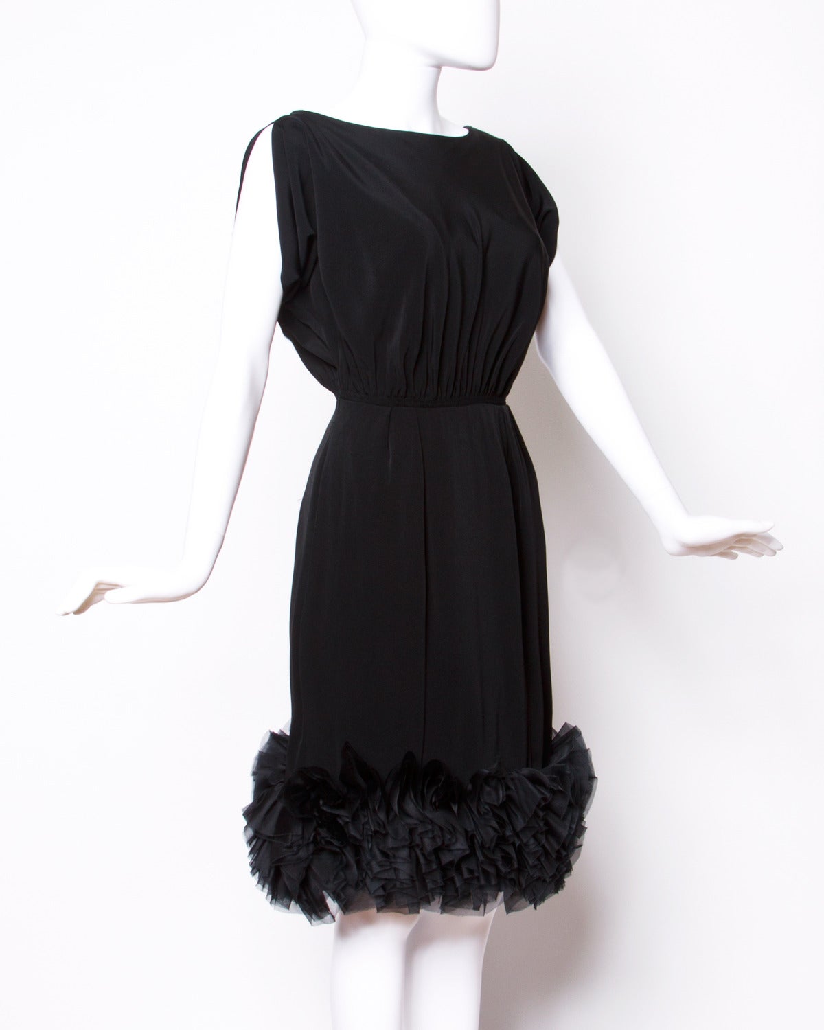 Chic black silk cocktail dress with a ruffled hem and dolman sleeves.

Details:

Fully Lined
Back Metal Zip and Hook Closure
Estimated Size: Medium
Color: Black
Fabric: Feels like Silk Crepe

Measurements:

Bust: Free
Waist: 28