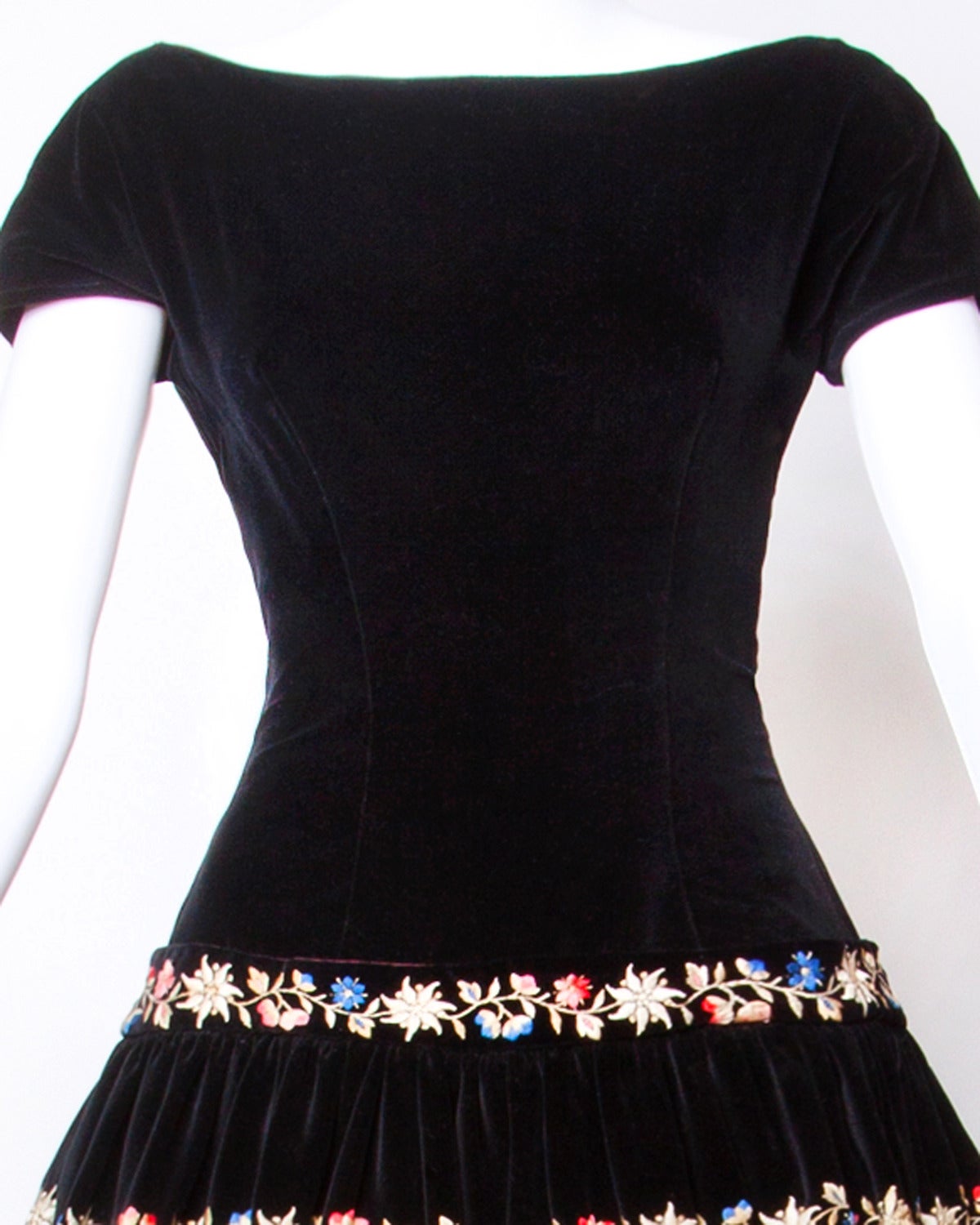 Early 1950s black velvet cocktail dress with colorful floral embroidery. Full sweep.

Details:

Fully Lined
Back Metal Zip Snap and Hook Closure
Estimated Size: Small
Color: Black/ Multicolored
Fabric: Velvet

Measurements:

Bust: Up To