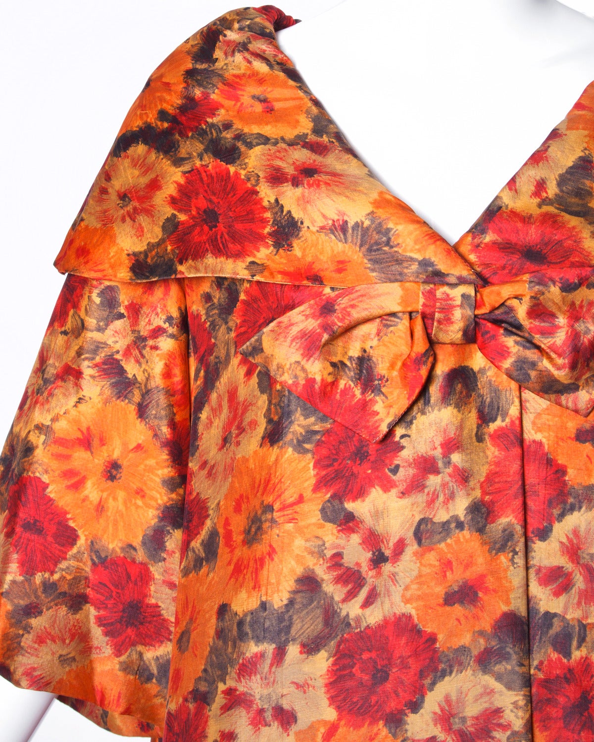 Floral printed silk swing coat with bell sleeves and a full sweep by Sandra Sage. Oversized bow detail and giant pop-up collar.

Details: 

Fully Lined
Front Button and Hook Closure
Estimated Size: Free (Small-Large)
Color: Orange/ Red/