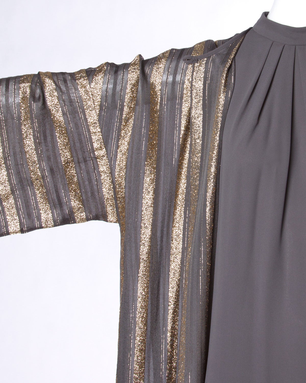 Gorgeous two-piece ensemble by Lucie Ann of Beverly Hills that can be worn together or separately. Sheer metallic gold striped duster and lined sleeveless maxi dress.

Details:

Partially Lined
Back Zip and Hook Closure on Dress/ Front Button