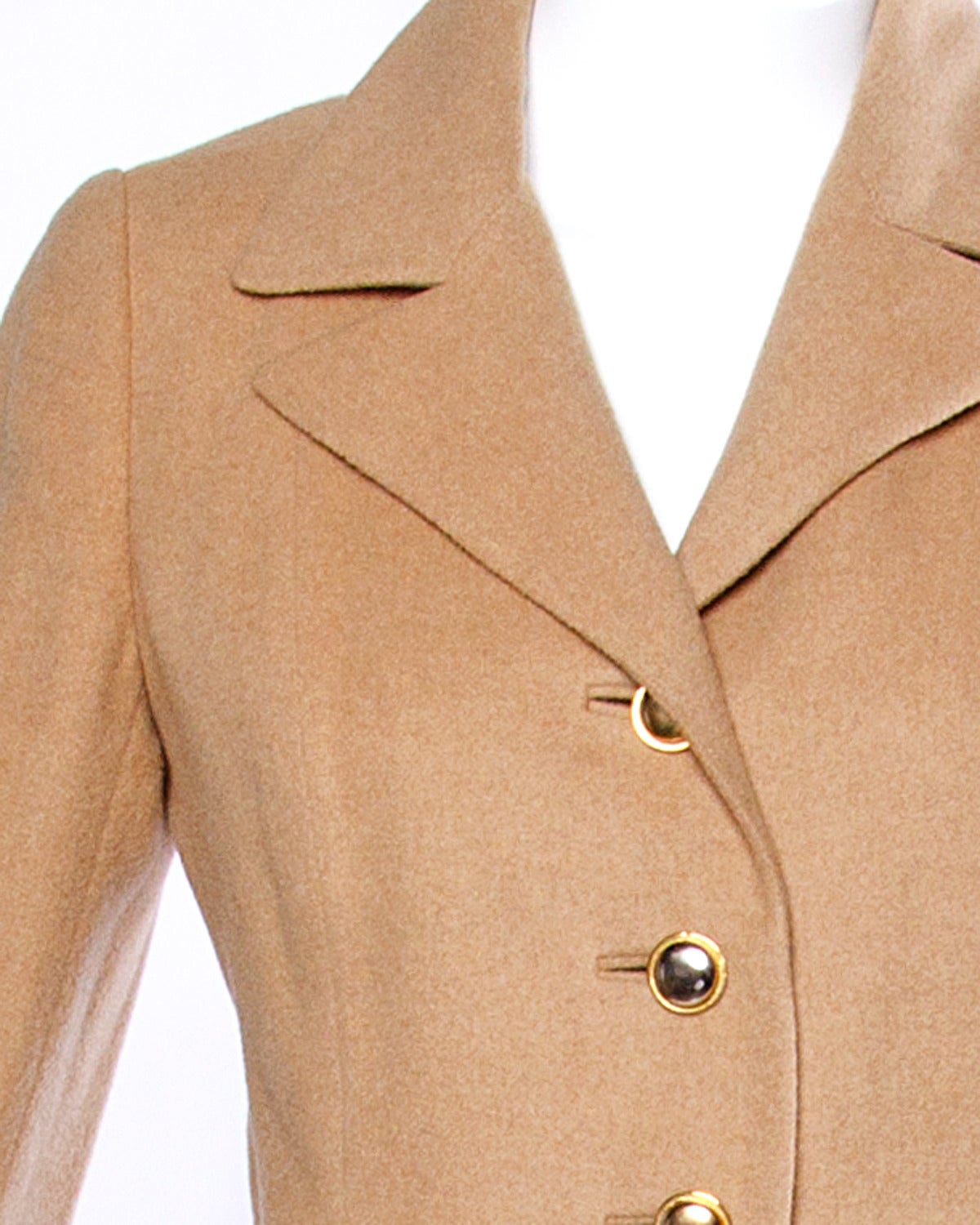 Unique matching jacket and skirt suit by Frances Heffernan with heavy duty goldtone hardware in 100% camel hair. The jacket buttons up the front and features custom tailoring and notched lapels. The skirt snaps into place and is finished by a heavy