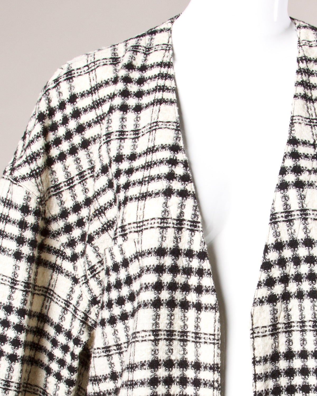 Vintage black and beige plaid cardigan duster by Sonia Rykiel. Front pockets and long sleeves.

Details:

Unlined
Front Pockets
No Closure/ Hangs Open
Colors: Black/ Beige
Estimated Size: Small Medium
Fabric: 94% Wool / 6% Polyamide
Label: