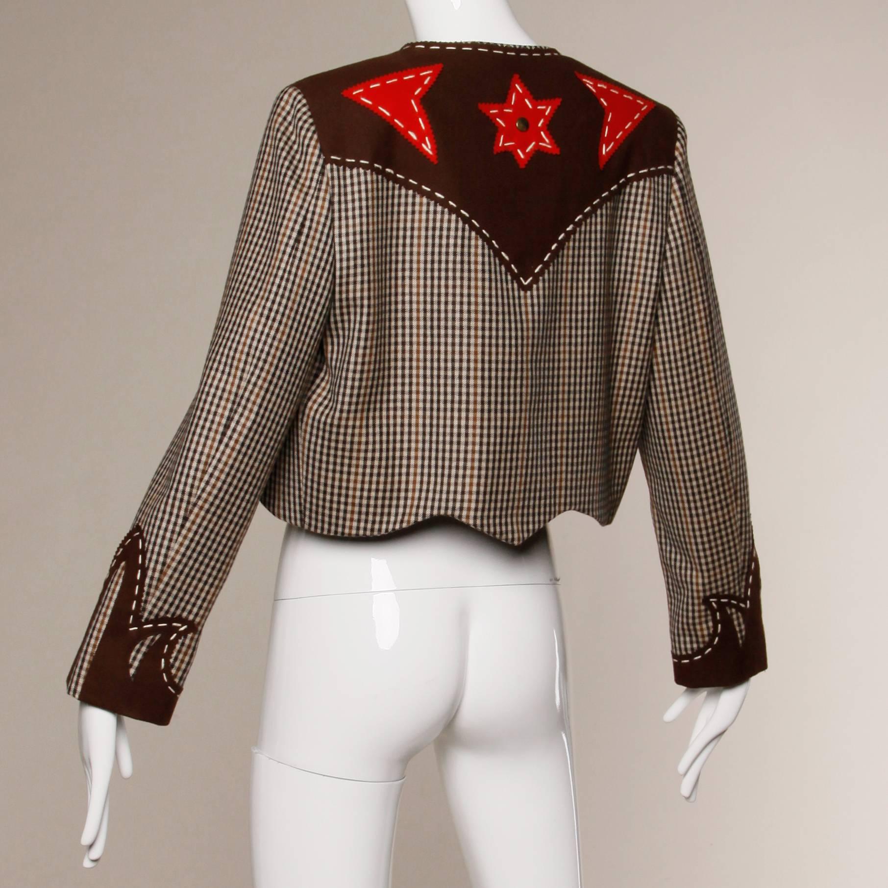 Darling vintage Western-inspired Moschino jacket with red star spur appliques and a cut out heart in the front. Contrasting oversize stitching with single front hook closure. Fully lined. Marked size is a US 10. The bust measures 38