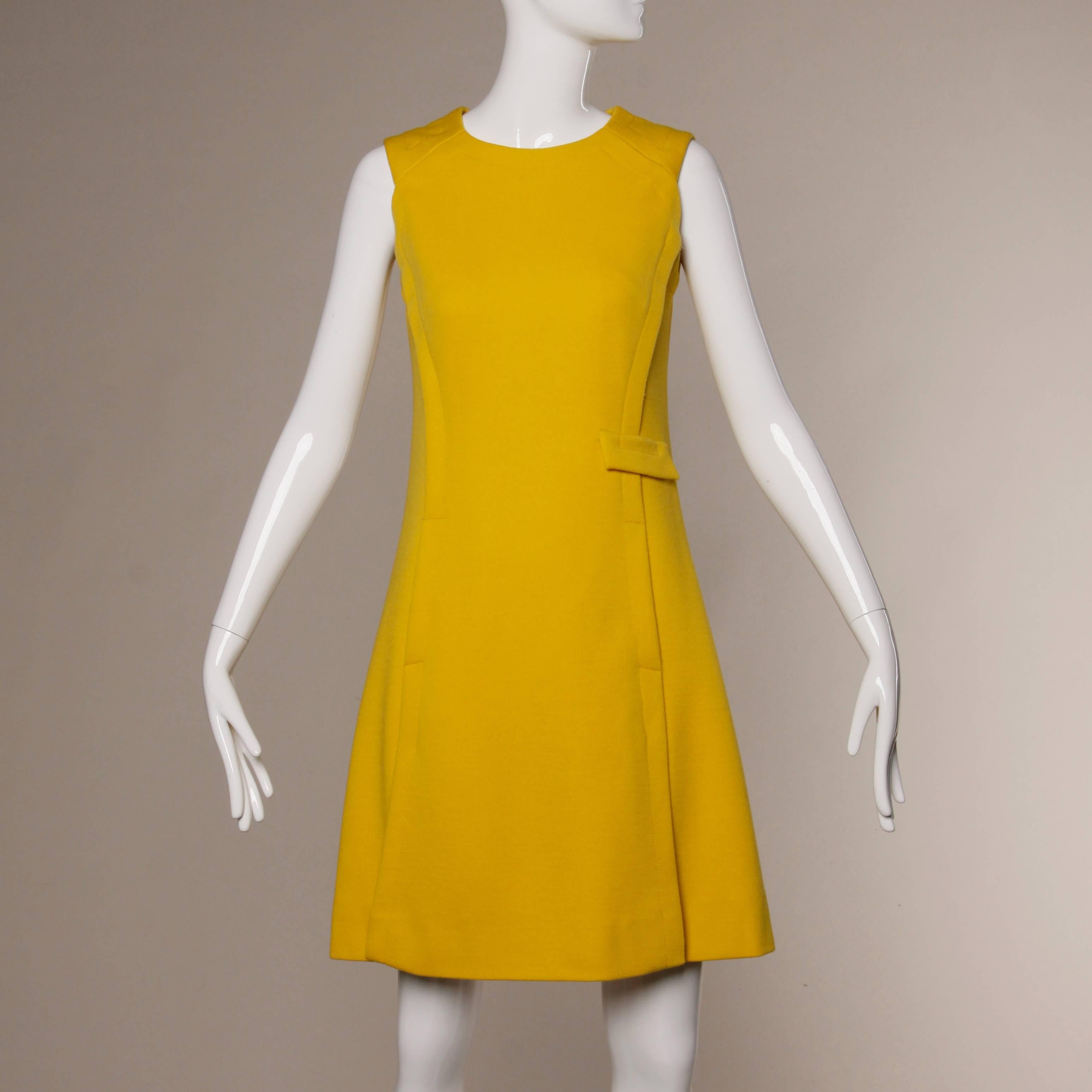 Bright mustard yellow 1960s two piece shift dress and coat set. Both pieces are fully lined and appear to be custom tailored. Dress features a two front hidden pouch pockets and a faux slit pocket. Rear zip closure. Coat features double breasted