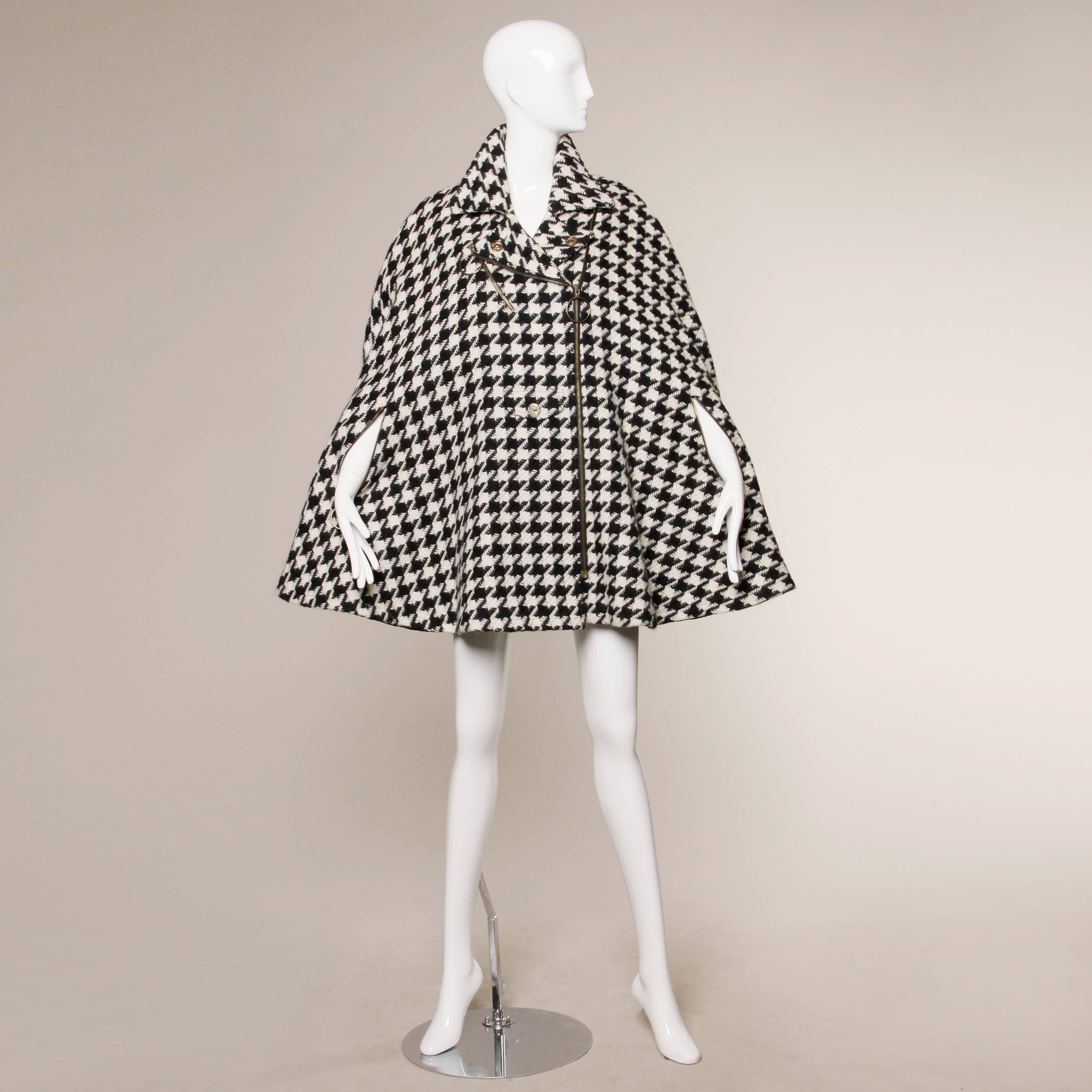 Gorgeous heavy black and off white houndstooth cape coat with Cheap & Chic heart buttons, zippered arm slits with jump ring pulls and quilted lining. Fabric content is 50% mohair 50% wool. The cape zips up the front and has a structured collar.