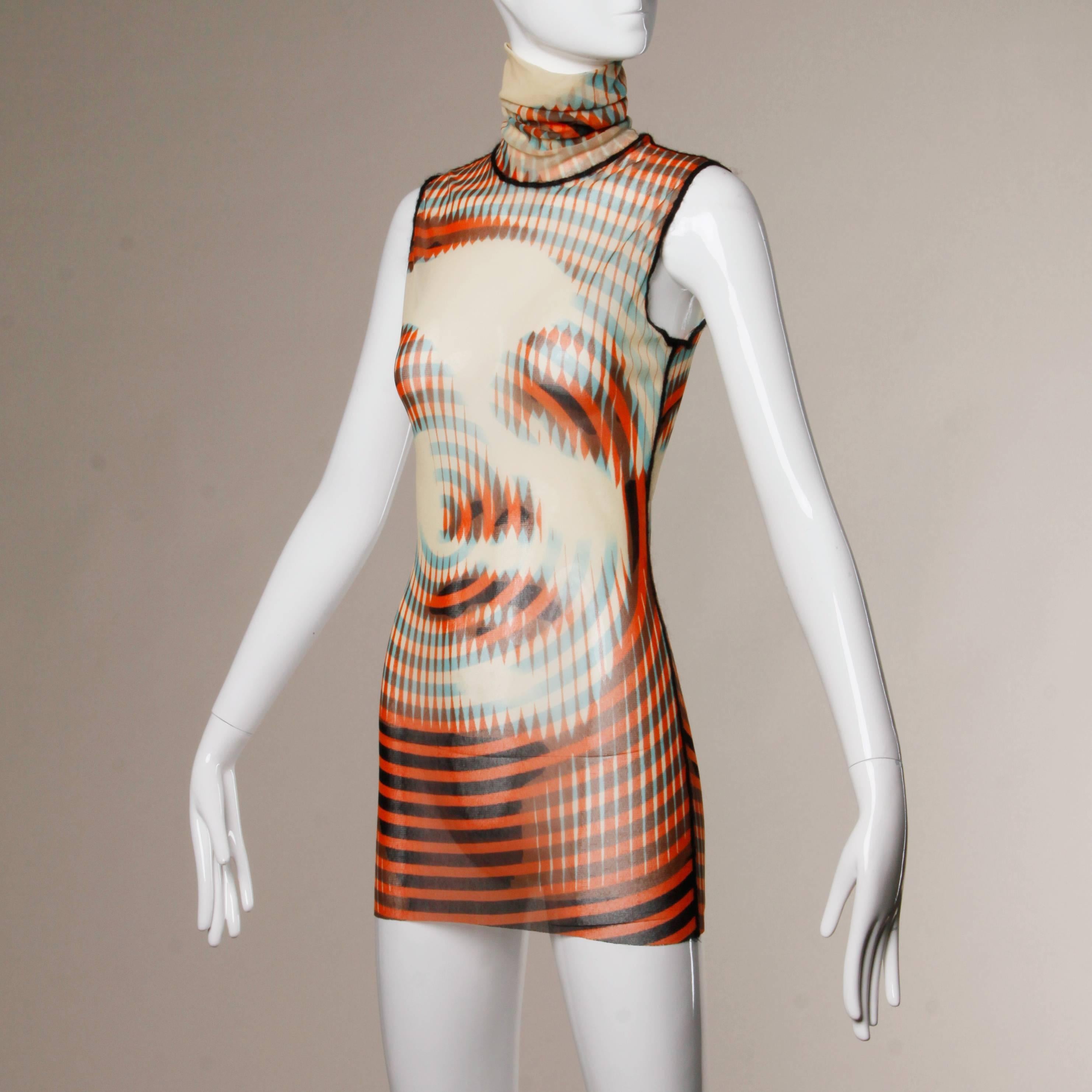 Iconic Jean Paul Gaultier turtle neck mesh top with an optical illusion graphic of a woman's face. The fabric content is not marked but it feels like nylon. Made in Italy. The marked size is medium. Please note that there is a small break in the