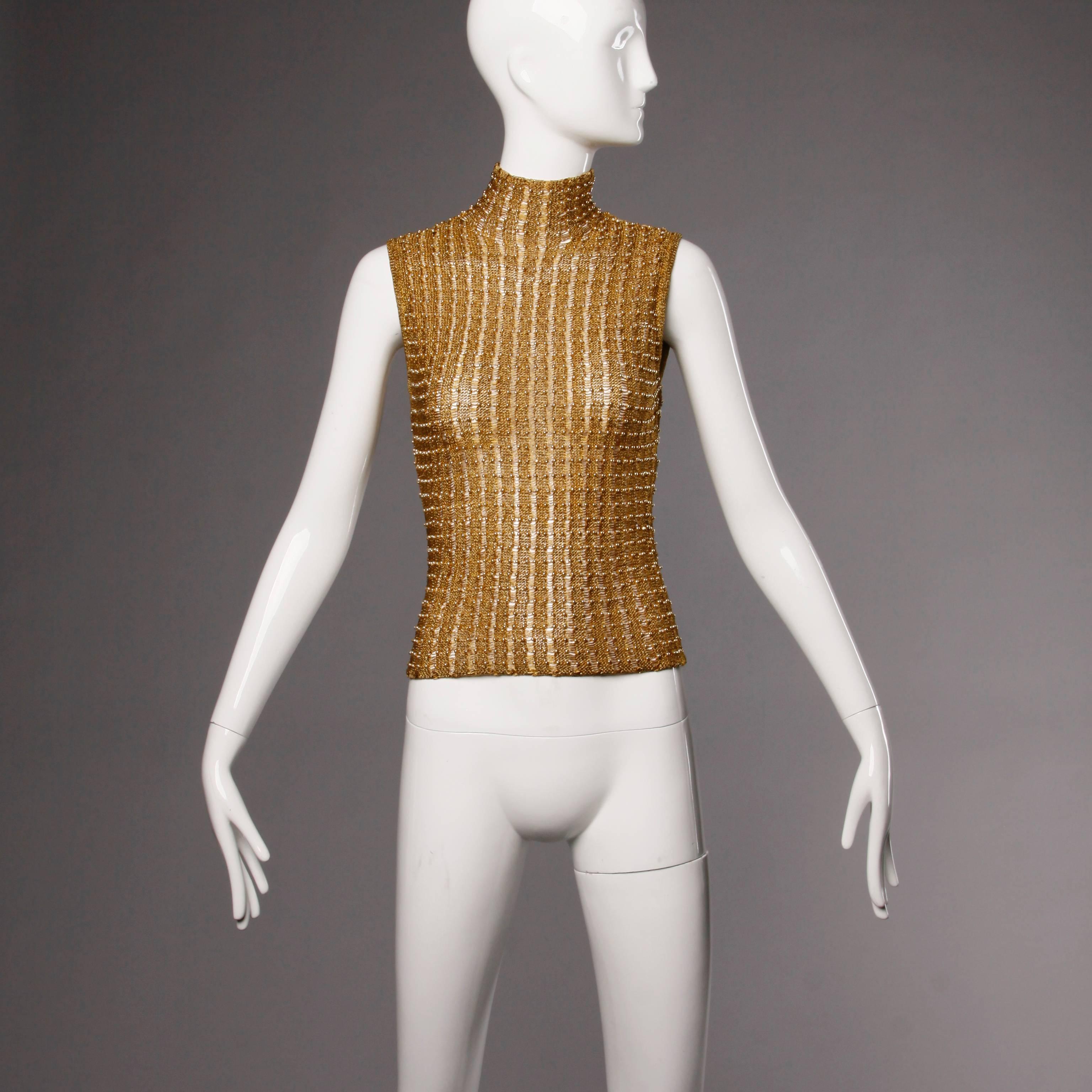 Krizia 1990s metallic gold knit sweater top with a turtle neck. Sleeveless sleeves and button closure at the back of the neck. Unlined. 75% Viscose/ 13% Polyester. Marked size Italian 42. Fits like a modern US size small. The measurements are as