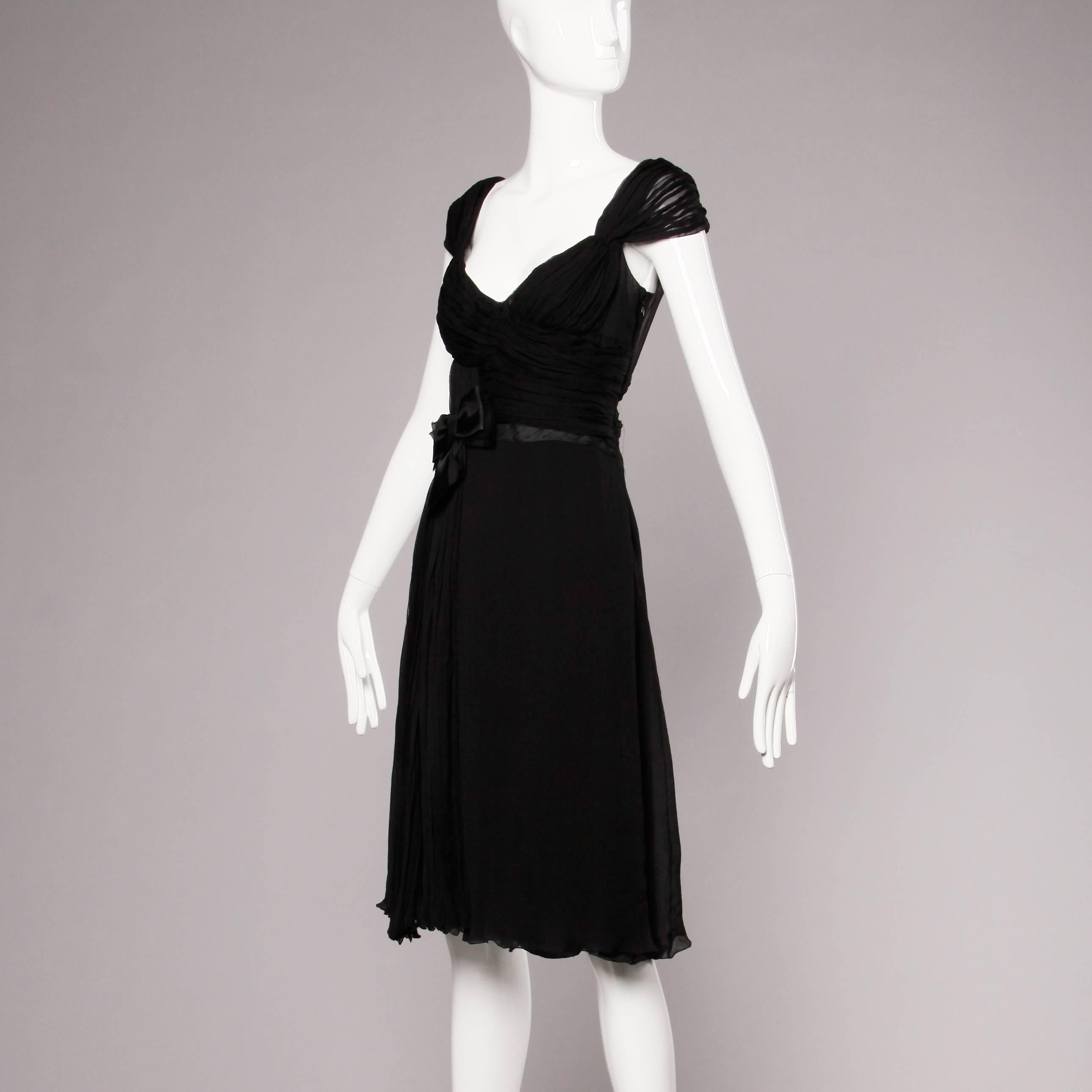 Beautifully finished black silk chiffon black cocktail dress with an asymmetric bow detail by Prada. Fully lined in silk. Rear zip closure. Marked size is I 42/ US 4-6. Fits true to size.

Details: 

Fully Lined in Silk 
Side Zip with Hook