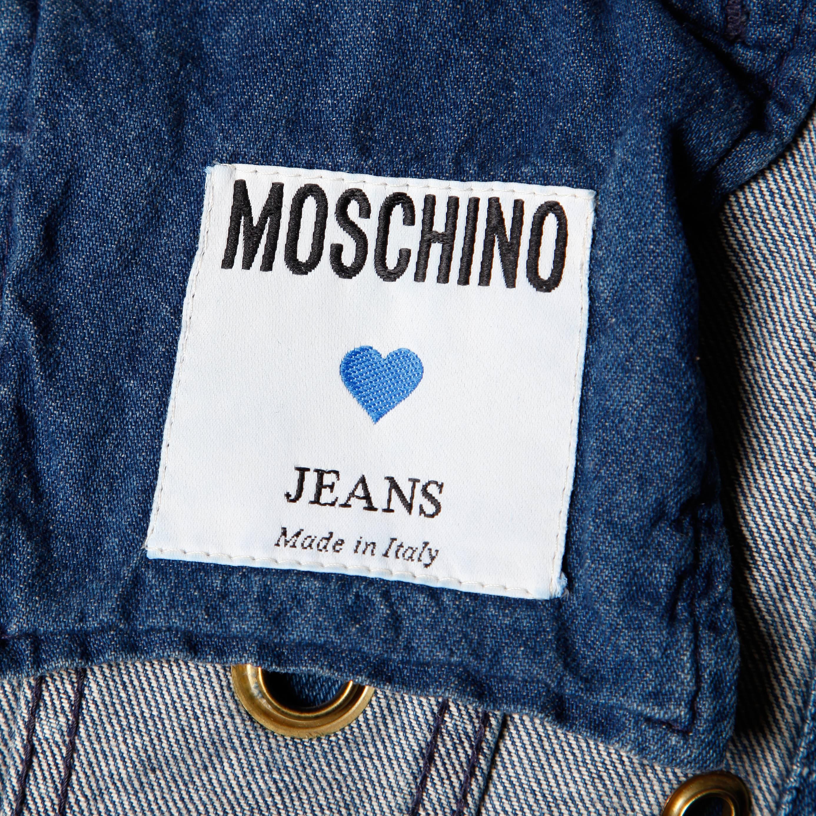 Worn in vintage denim jacket with cut out rivet detail by Moschino Jeans. Unlined with front button closure and cropped sleeves. 100% Cotton. Made in Italy. The marked size is 42 and the jacket fits like a modern small-medium. The measurements are
