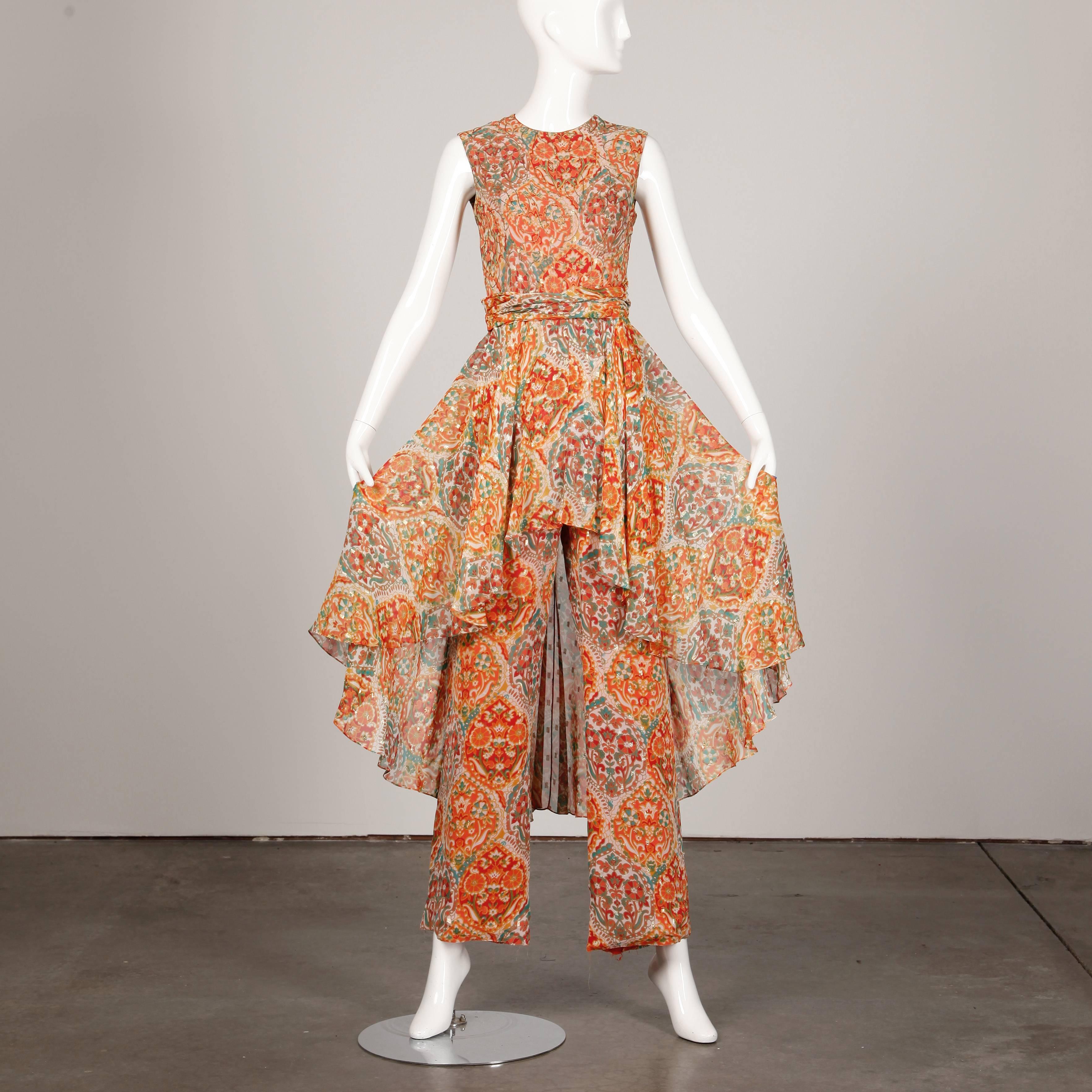 Own a piece of fashion history! This 1960s metallic flecked and embroidered jumpsuit by Oscar de la Renta features an asymmetric hem over skirt and sleeveless sleeves. Rear zip closure with ruched waistband that hooks in the back. Fully lined. Fits