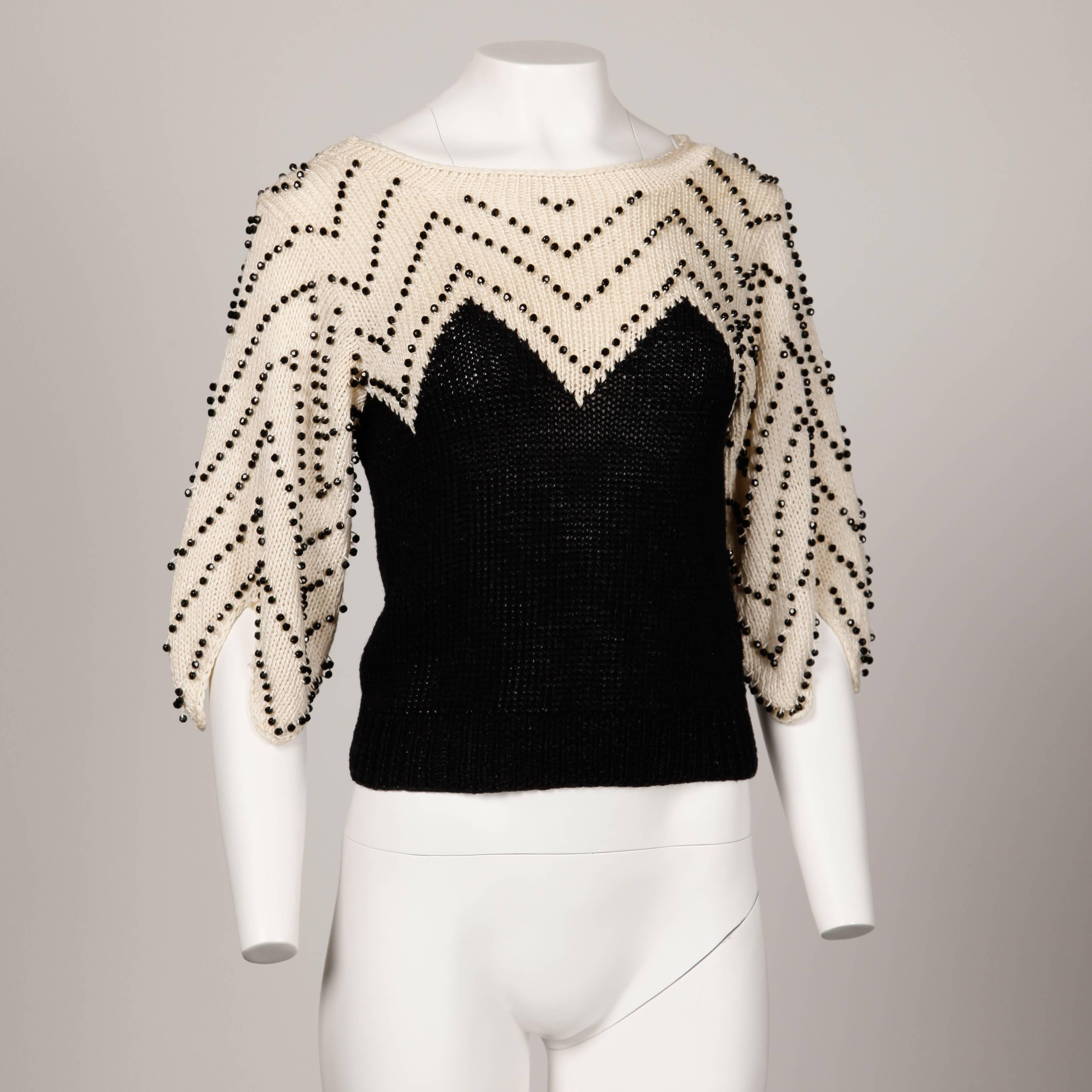 Incredible hand knit sweater top with heavy chevron beadwork and jagged sleeves by Lillie Rubin. Unlined. Fabric content is 50% acrylic, 42% rayon, 8% wool. The marked size is small and the sweater fits true to size. The bust measures 34-38