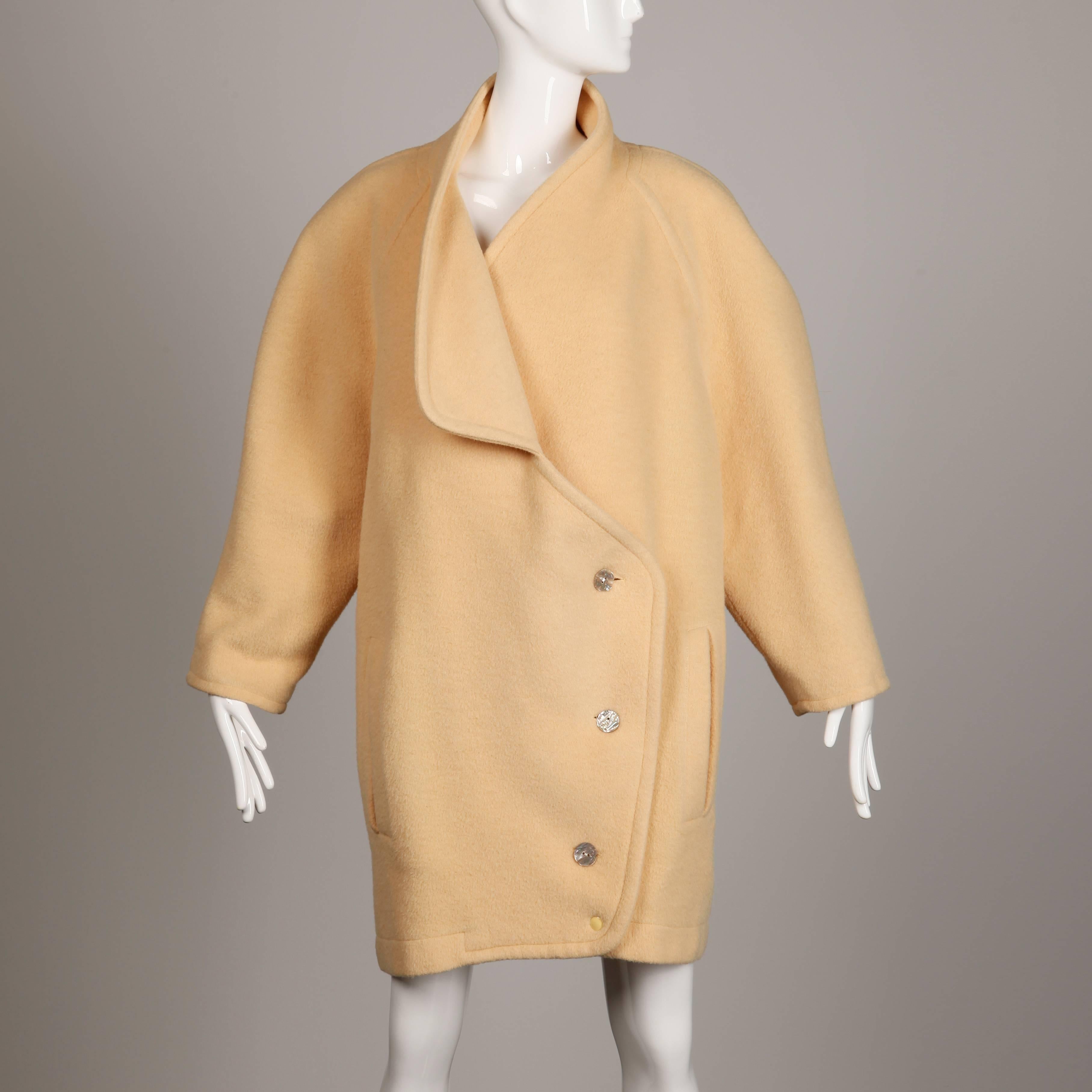 Unique vintage wool coat by Claude Montana from the 1980s. Oversized boxy shape and asymmetric cut. Partially lined with front shell button closure. The fabric content is 50% llama, 30% wool, and 20% cashmere. The marked size is US 8, I 42, F 40, D