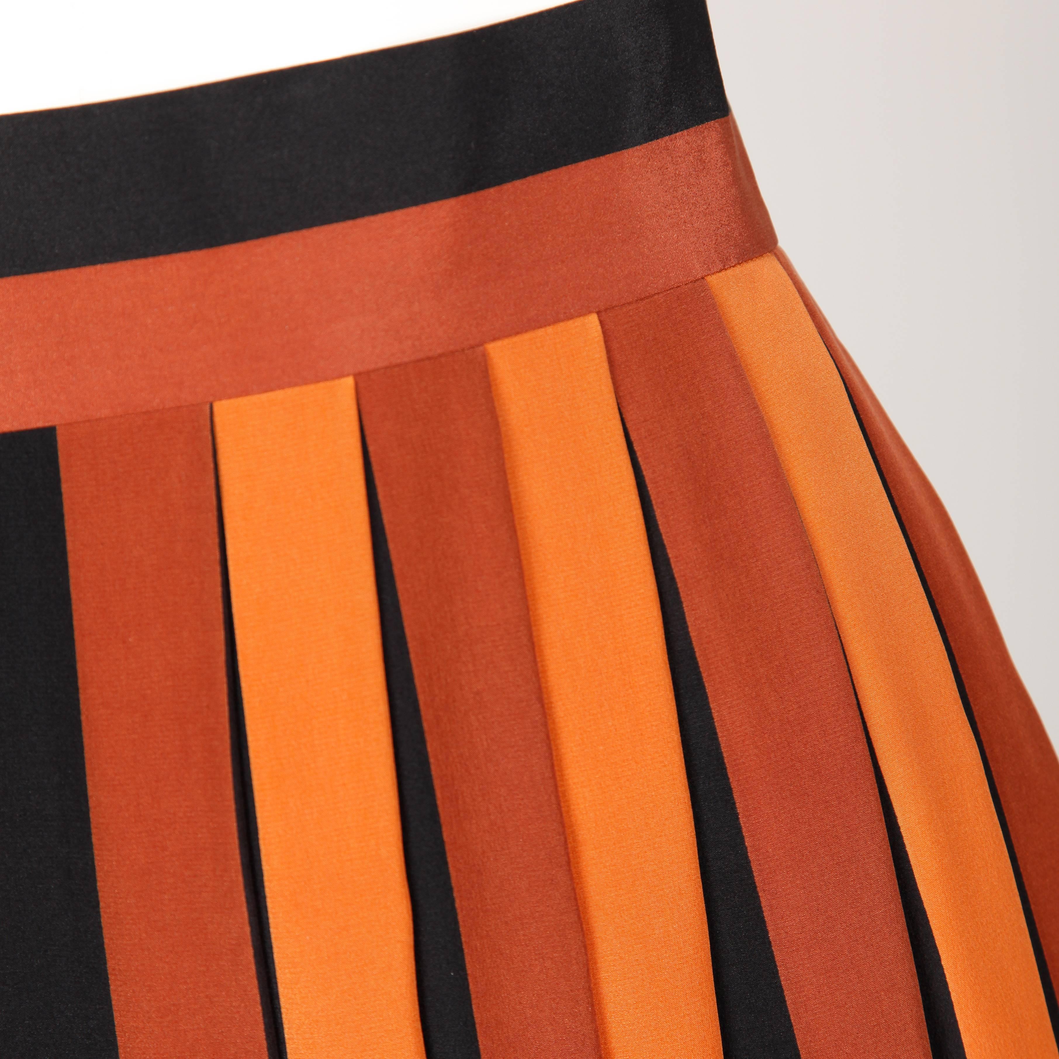 Wonderful 1970s silk pleated color block skirt by Givenchy. Rust, black, white, neutral and orange colors with inverted pleats and a striped waistband. Marked size 38, fits like a modern size small. 100% Silk. Unlined with zip and hook closure. Made
